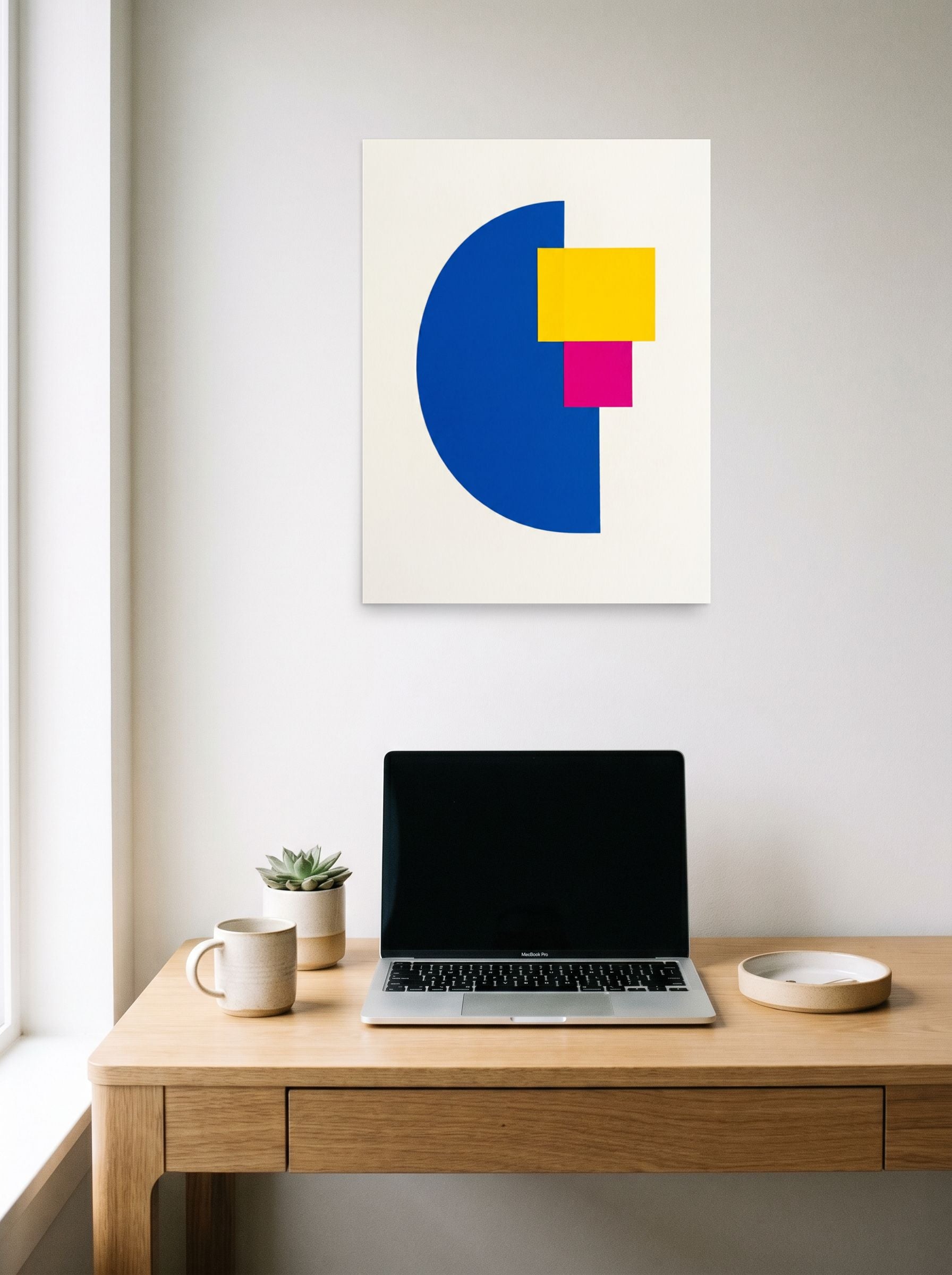 A 18x24 inch unframed paper Geometric abstract art print of 'Primary Intersection' hanging above a worktable with a laptop.