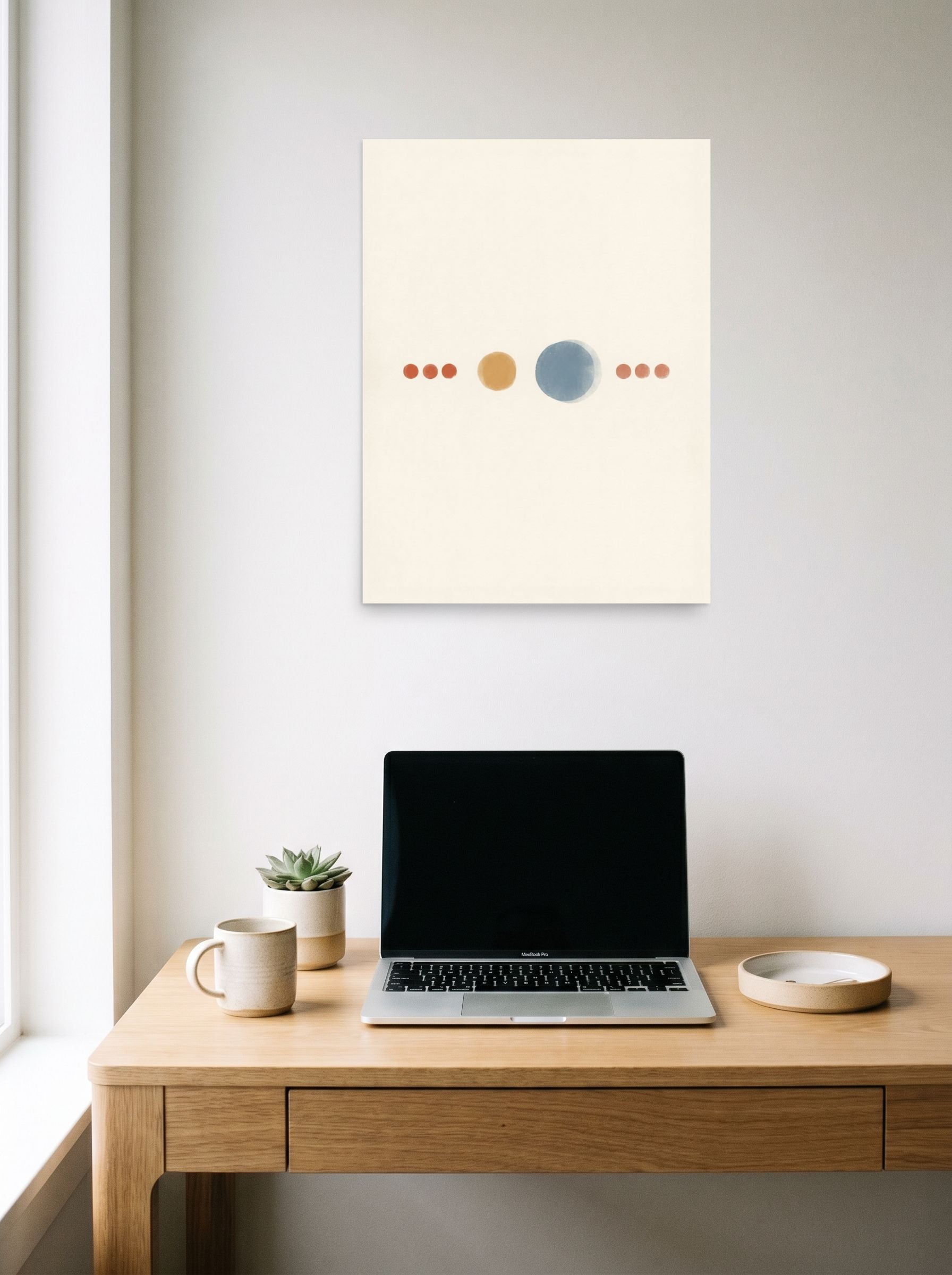 A 18x24 inch unframed paper Minimalism print of 'Celestial Alignment' hanging above a worktable with a laptop.