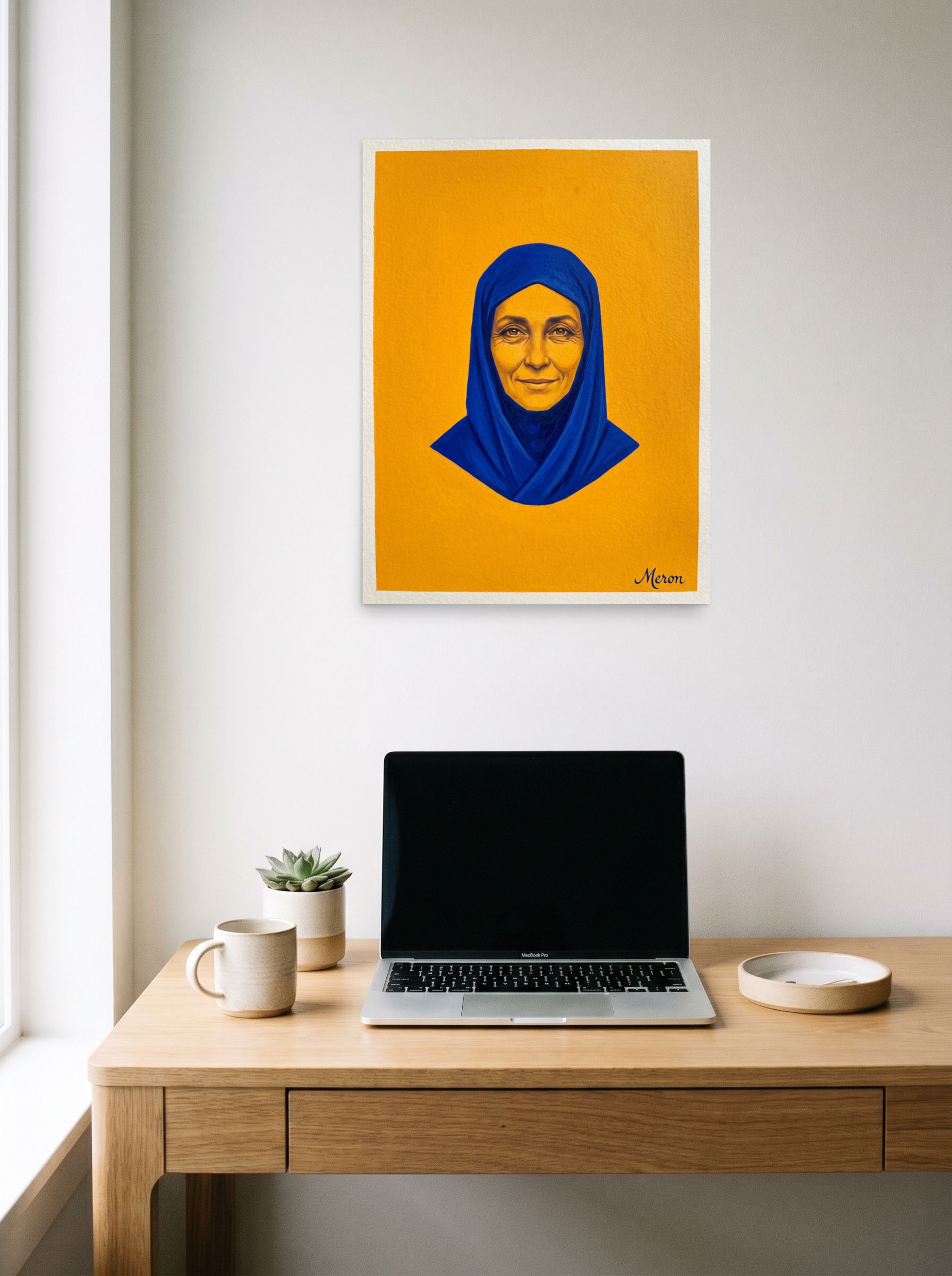 A 18x24 inch unframed paper Pop art print of 'Azure Serenity' hanging above a worktable with a laptop.