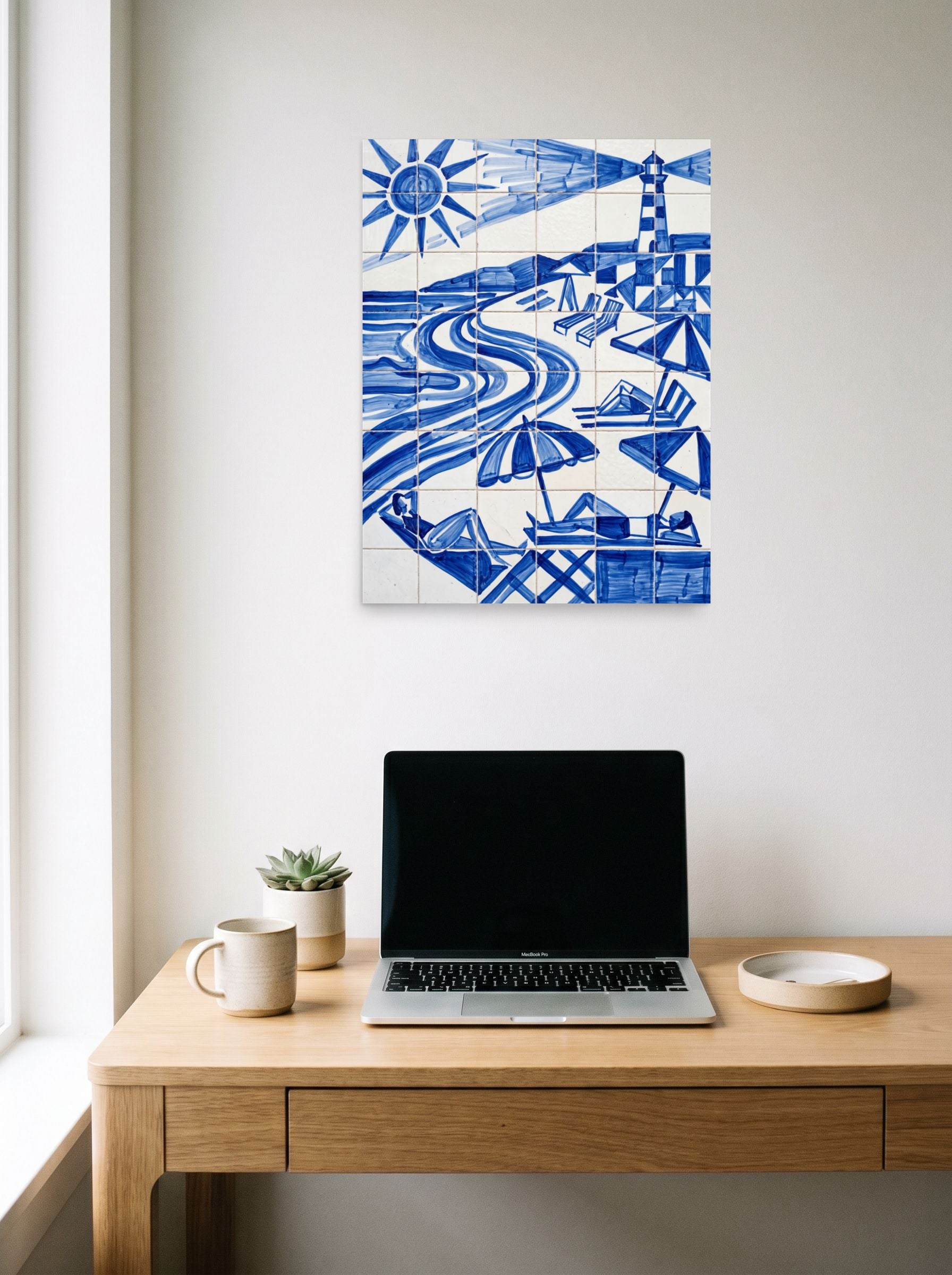 A 18x24 inch unframed paper Geometric abstract art print of 'The Blue Riviera' hanging above a worktable with a laptop.
