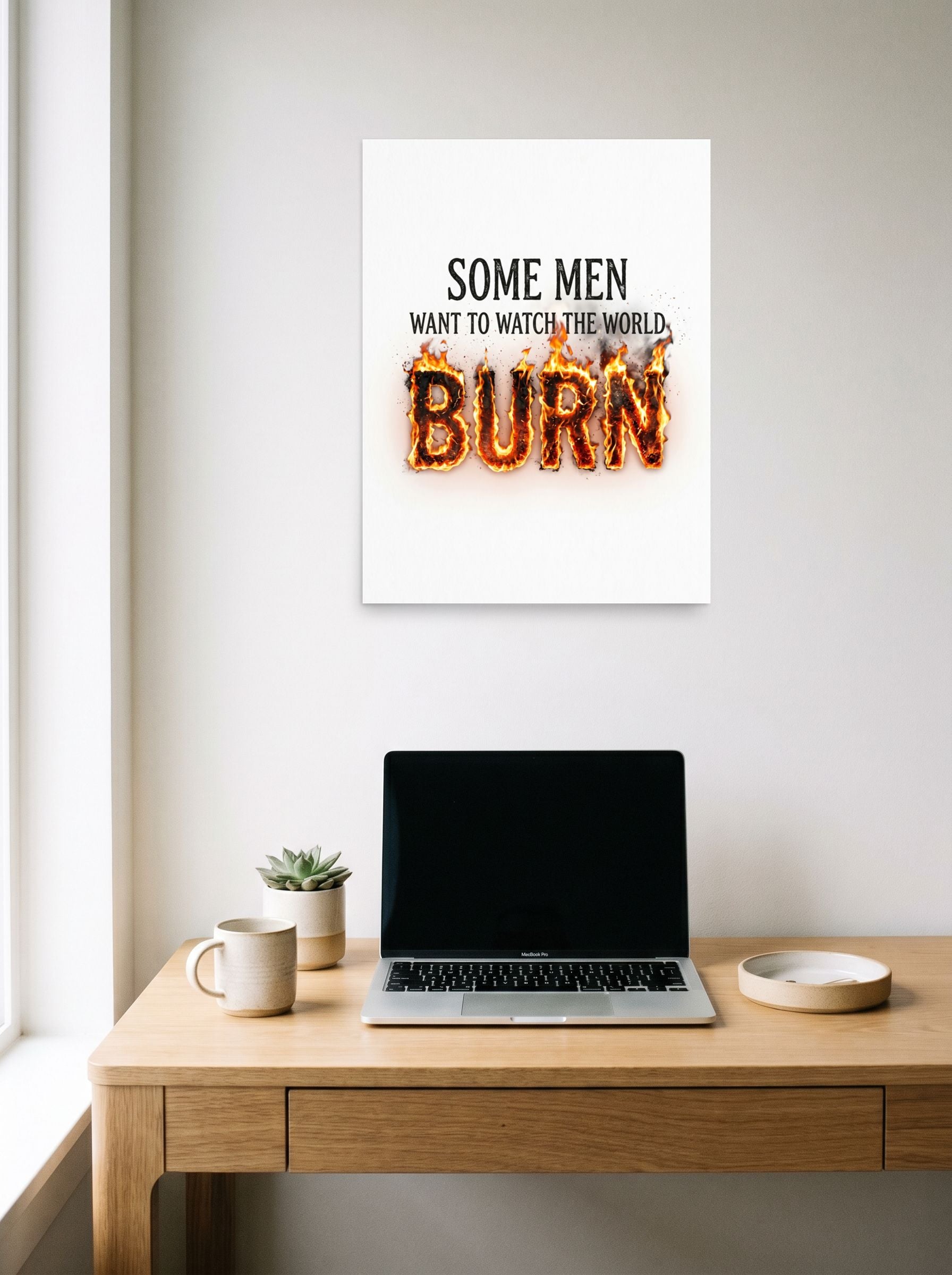 A 18x24 inch unframed paper Digital art,Pop art print of 'Watch the World Burn' hanging above a worktable with a laptop.