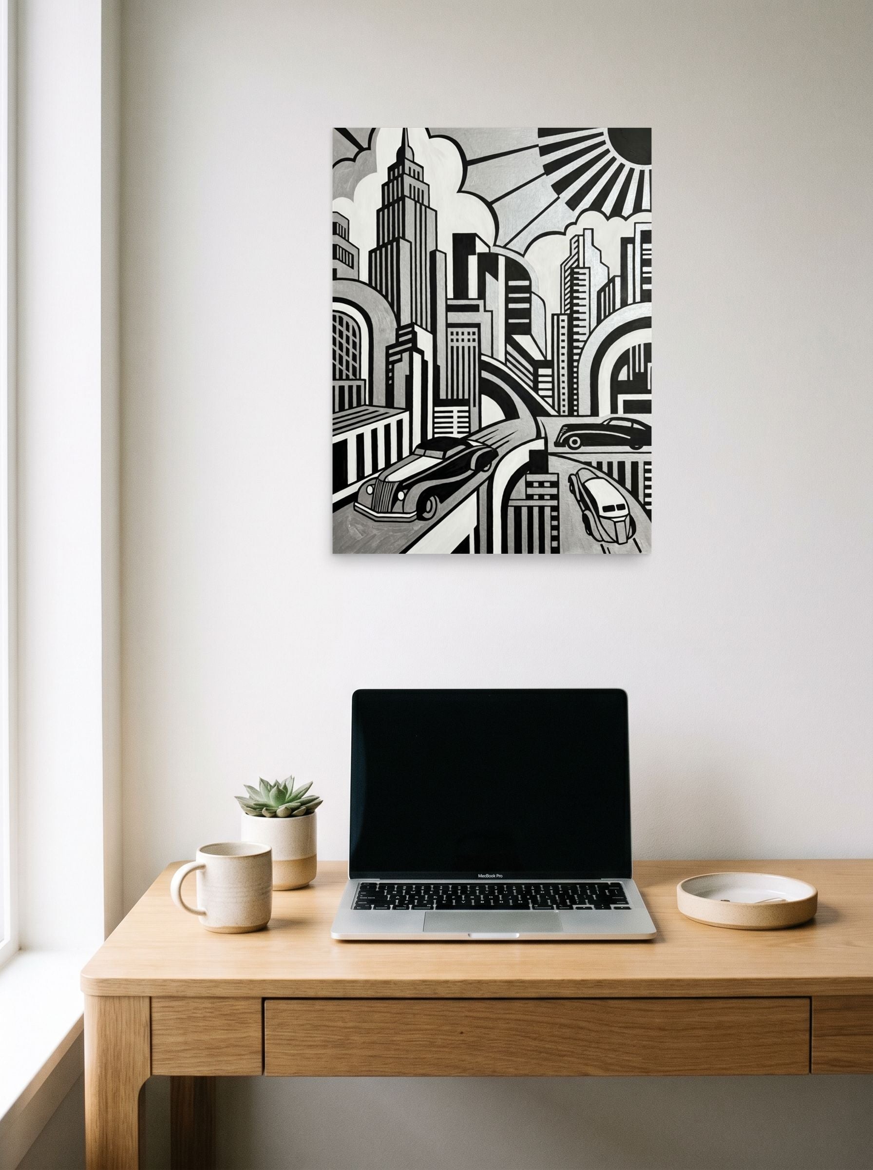 A 18x24 inch unframed paper Art Deco print of 'L'Âge D'Or' hanging above a worktable with a laptop.