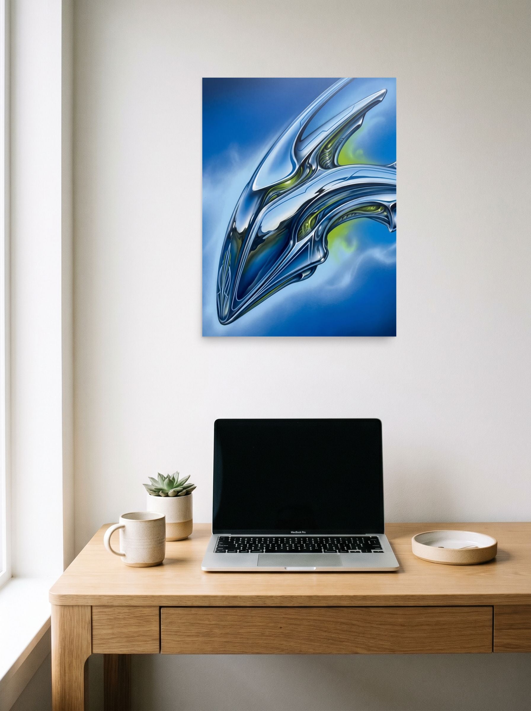 A 18x24 inch unframed paper Retrofuturism print of 'Chrome Horizon' hanging above a worktable with a laptop.