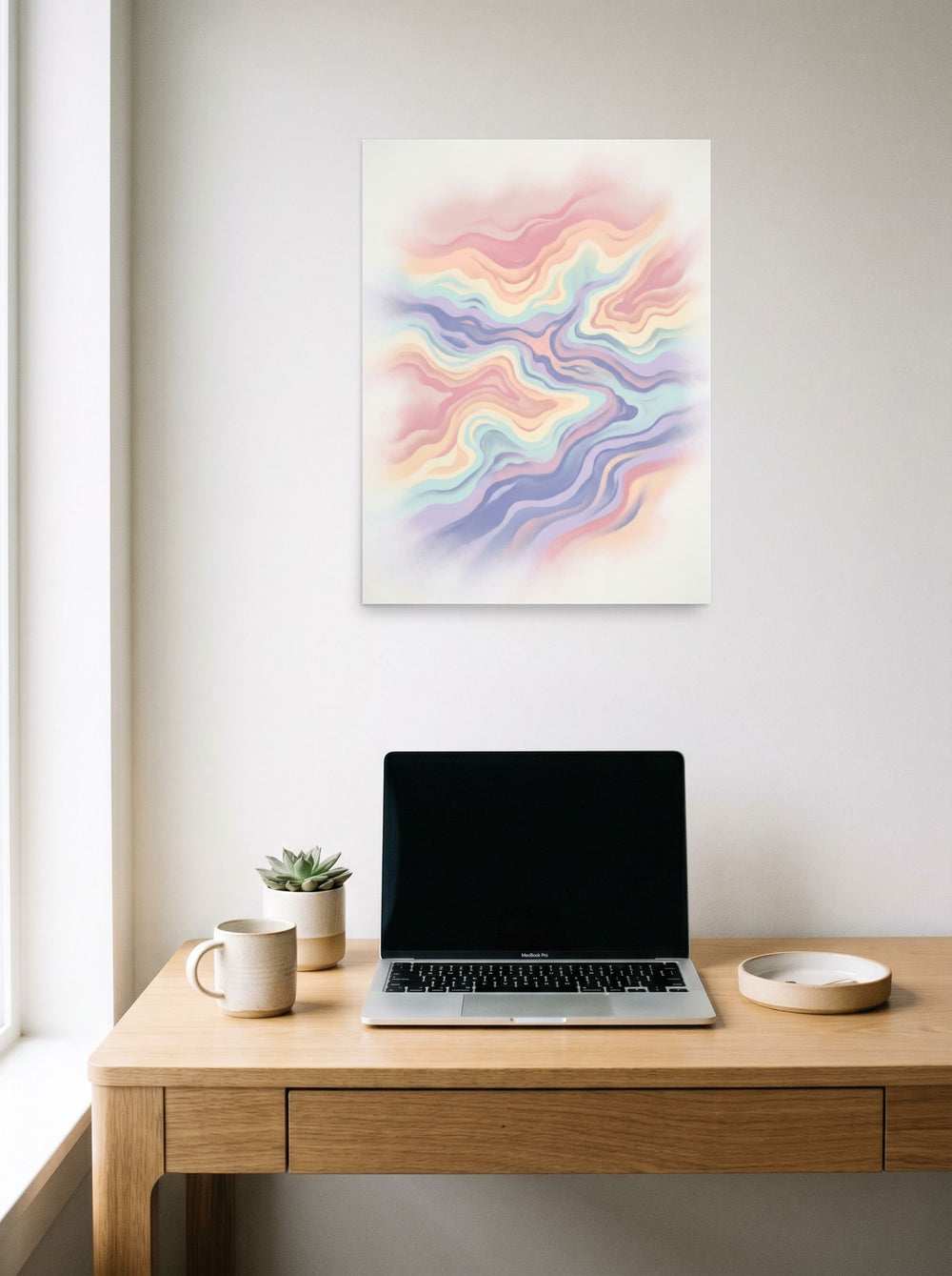 A 18x24 inch unframed paper Abstract art print of 'Pastel Waves' hanging above a worktable with a laptop.