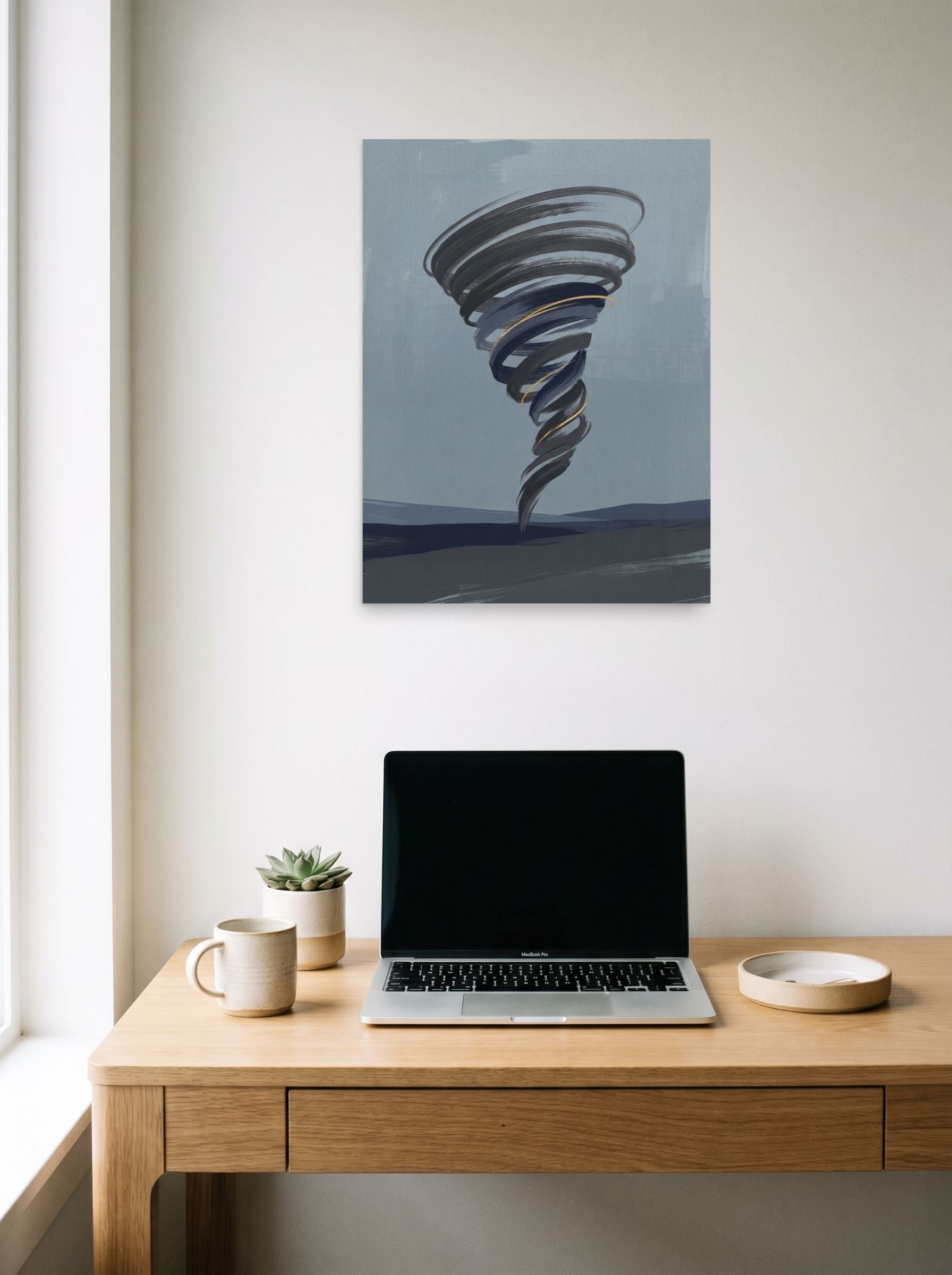 A 18x24 inch unframed paper Minimalism print of 'The Golden Vortex' hanging above a worktable with a laptop.