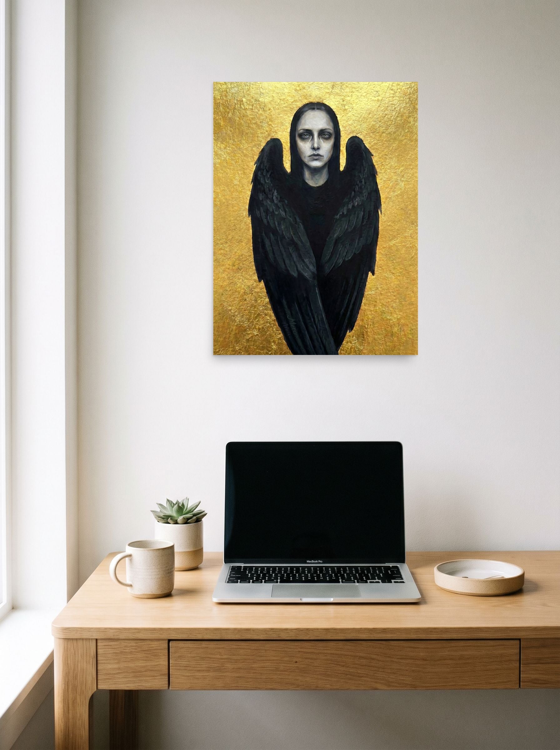 A 18x24 inch unframed paper Figurative art,Symbolism print of 'The Dark Seraph' hanging above a worktable with a laptop.