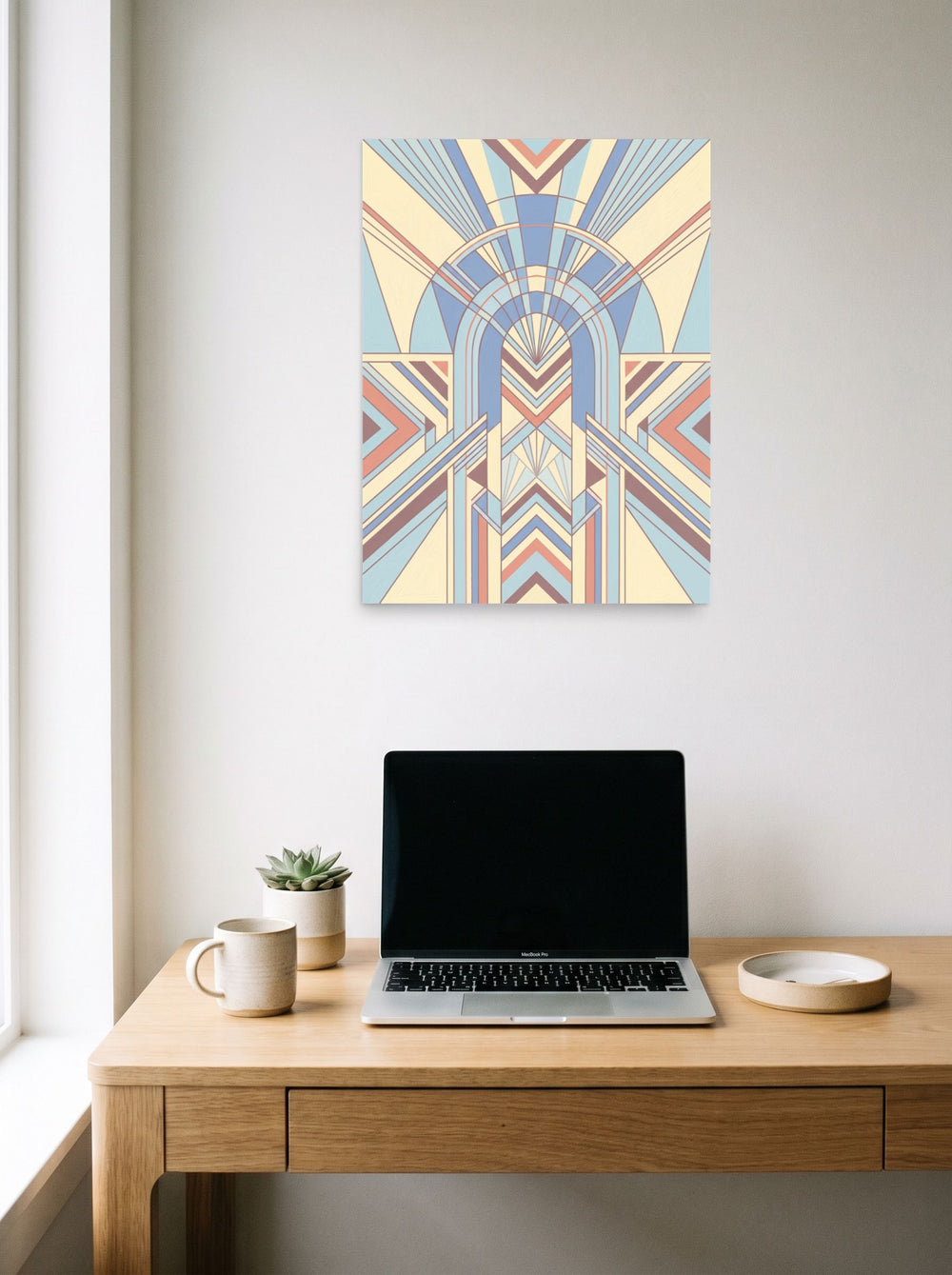 A 18x24 inch unframed paper Art Deco print of 'Pastel Deco Portal' hanging above a worktable with a laptop.
