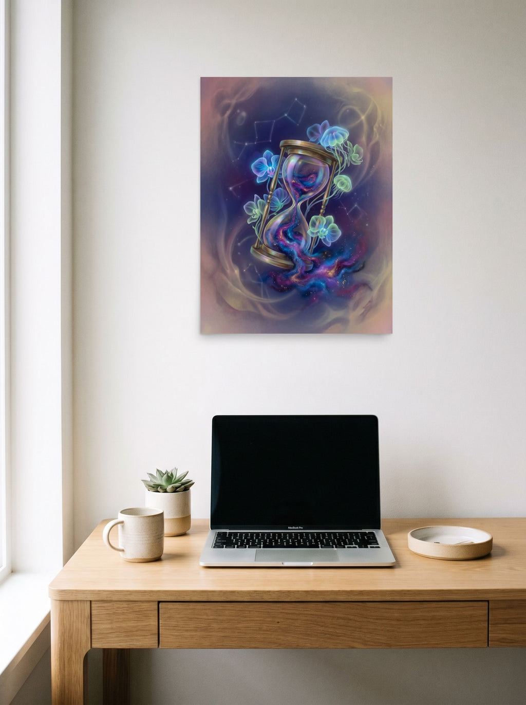 A 18x24 inch unframed paper Magic realism print of 'Sands of the Nebula' hanging above a worktable with a laptop.