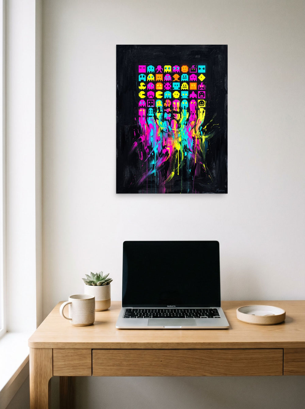 'Meltdown Arcade' hanging above a worktable with a laptop. A 18x24 inch unframed paper Pixel art print.