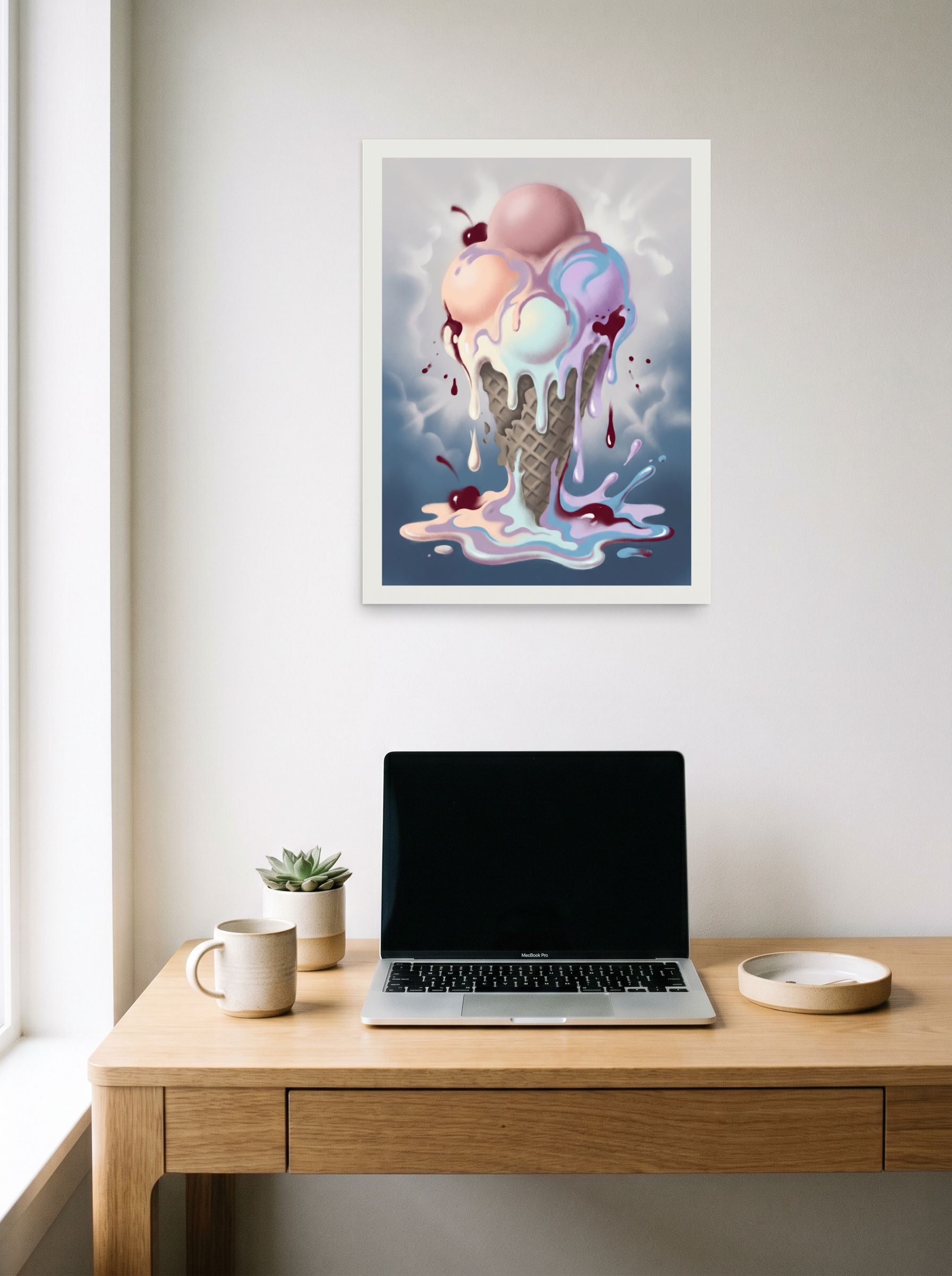 A 18x24 inch unframed paper Pop art print of 'Melting Pastels' hanging above a worktable with a laptop.