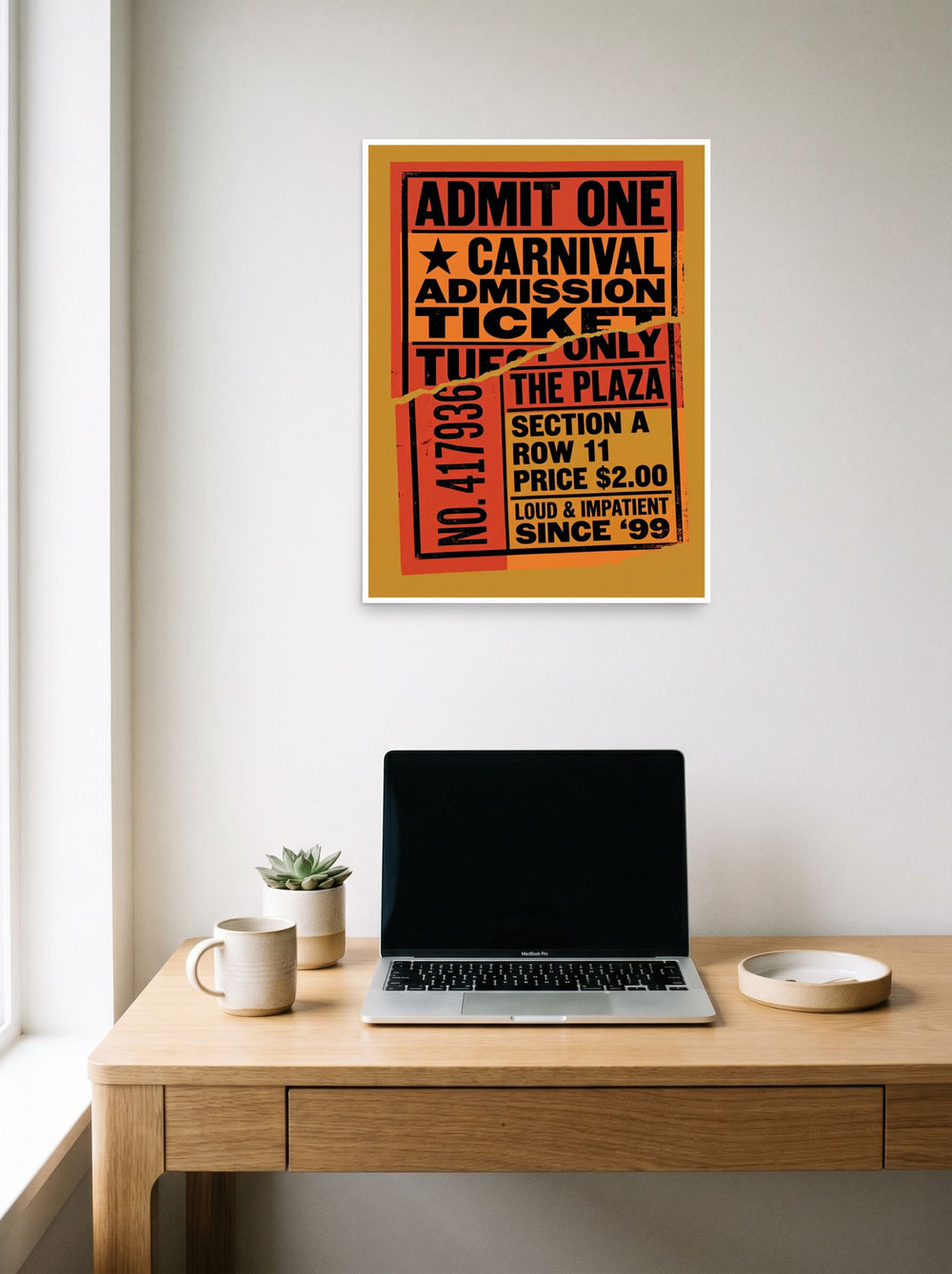 A 18x24 inch unframed paper Pop art print of 'Torn Admission' hanging above a worktable with a laptop.