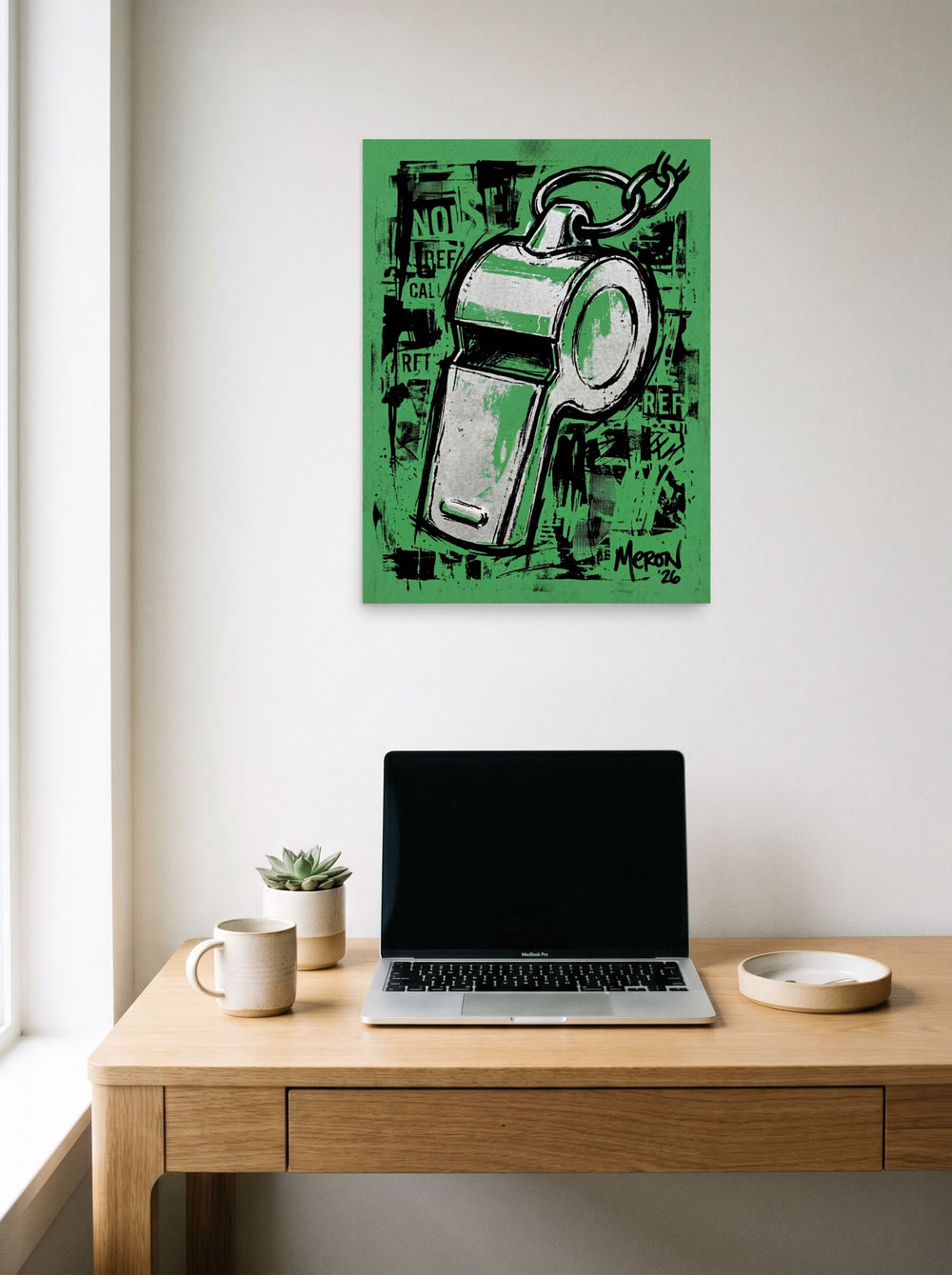 A 18x24 inch unframed paper Pop art print of 'The Referee's Call' hanging above a worktable with a laptop.