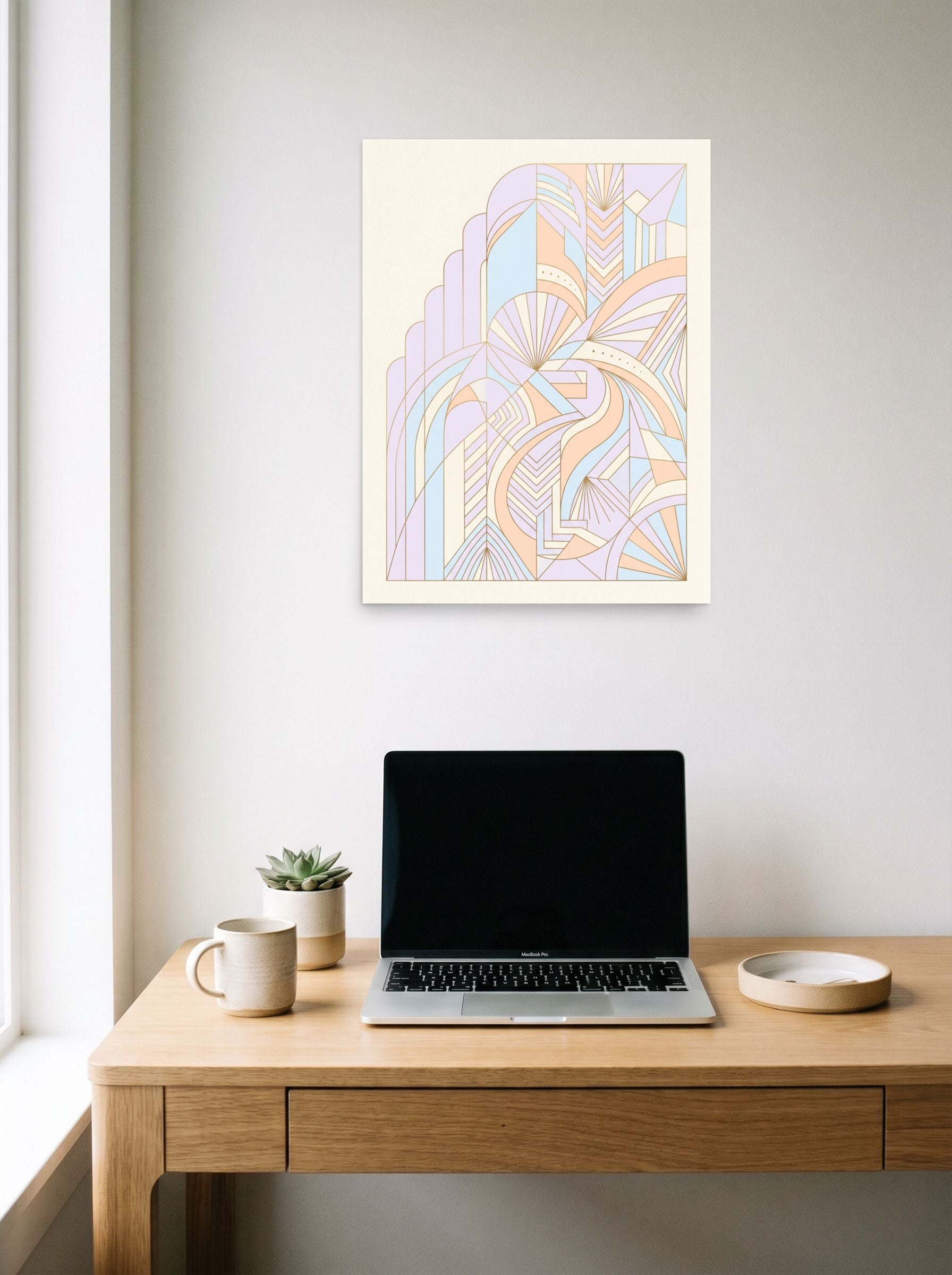 A 18x24 inch unframed paper Art Deco print of 'Deco Pastel Architecture' hanging above a worktable with a laptop.