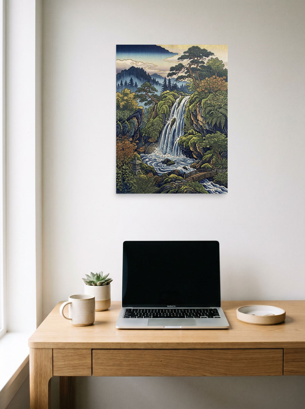 A 18x24 inch unframed paper Ukiyo-e print of 'Hidden Falls' hanging above a worktable with a laptop.