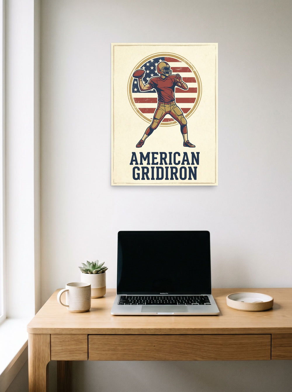 A 18x24 inch unframed paper Pop art print of 'The American Gridiron' hanging above a worktable with a laptop.