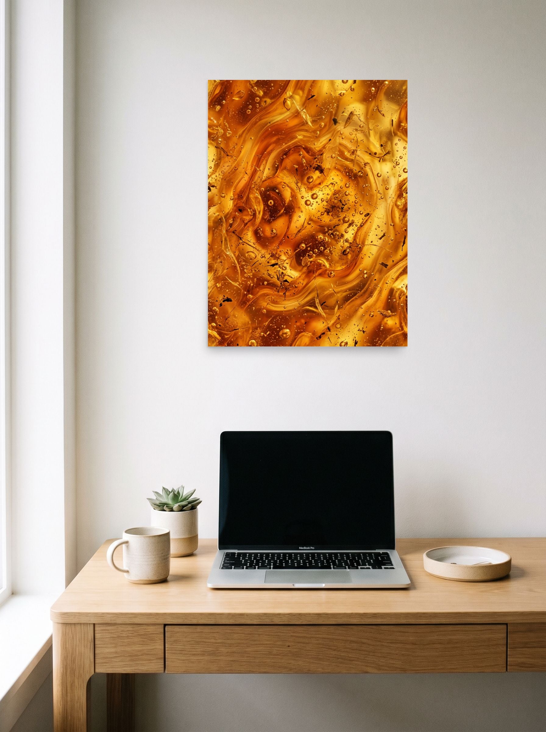 A 18x24 inch unframed paper Abstract art print of 'Amber Depths' hanging above a worktable with a laptop.