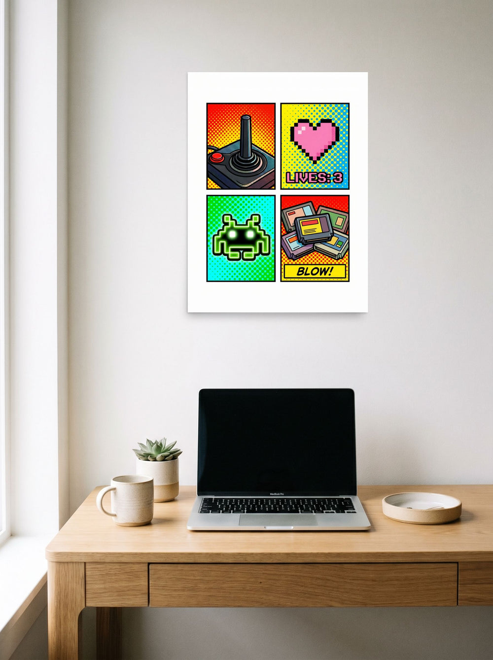 A 18x24 inch unframed paper Pop art print of 'Retro Arcade Memories' hanging above a worktable with a laptop.