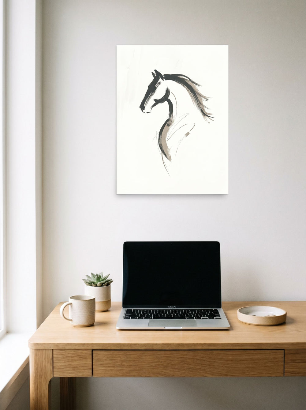A 18x24 inch unframed paper Minimalism print of 'Equine Spirit' hanging above a worktable with a laptop.