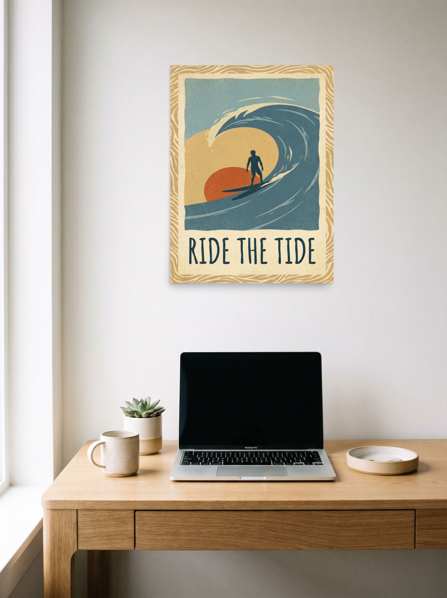 A 18x24 inch unframed paper Pop art,Digital art print of 'Ride the Tide' hanging above a worktable with a laptop.