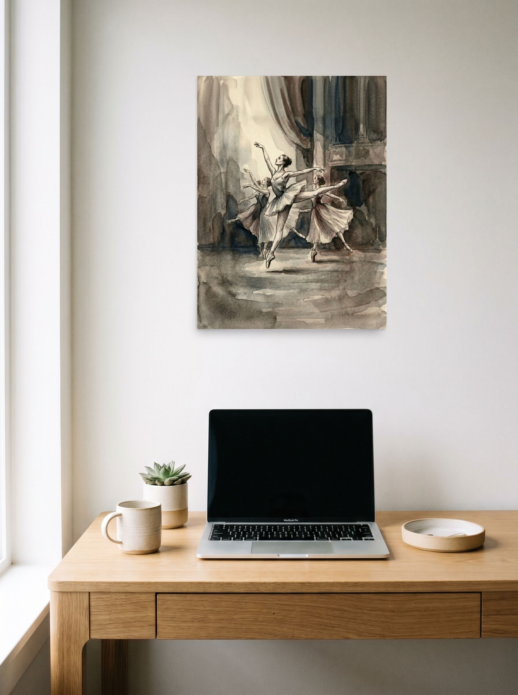 A 18x24 inch unframed paper Realism print of 'En Pointe' hanging above a worktable with a laptop.