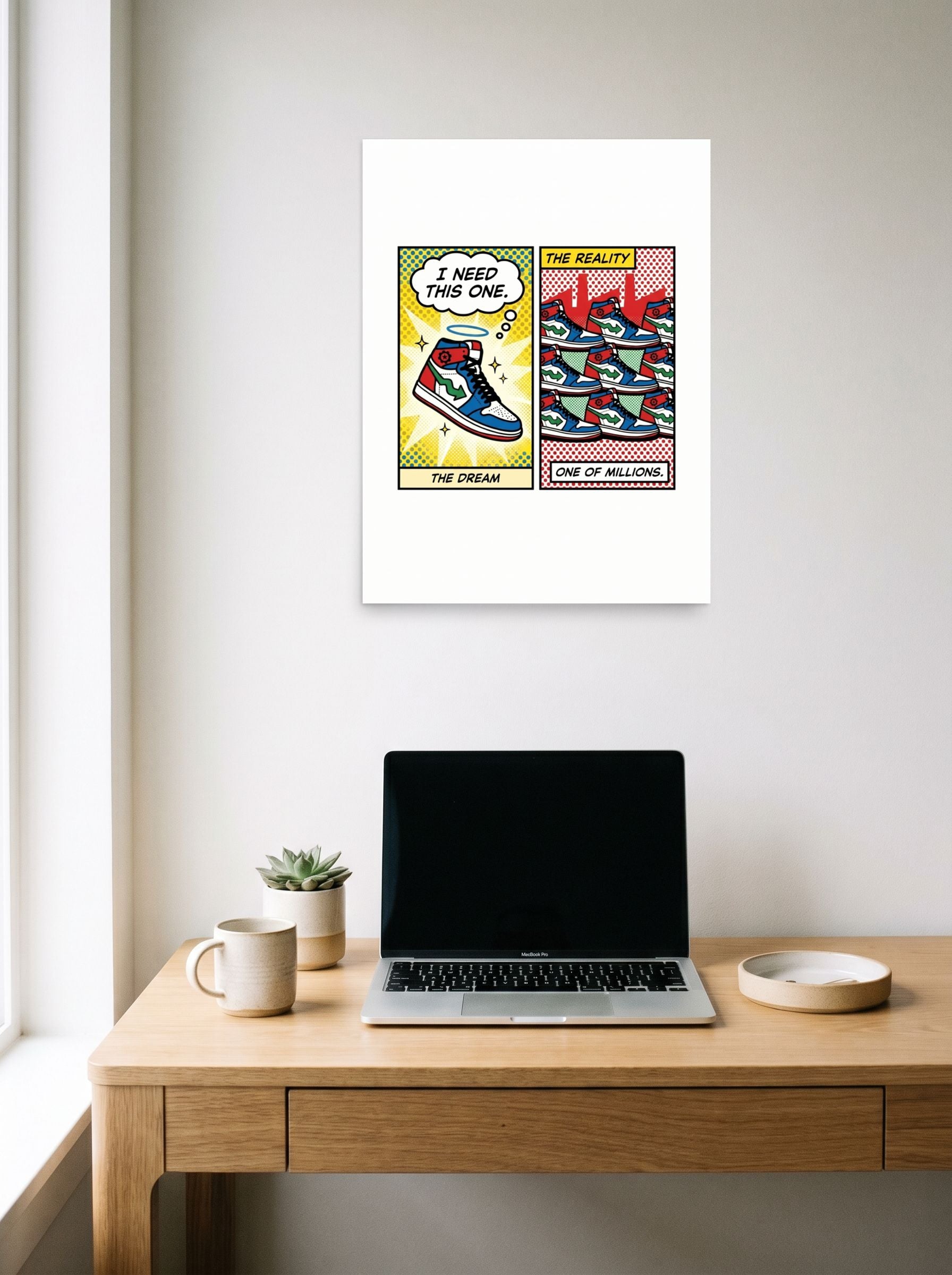 A 18x24 inch unframed paper Pop art print of 'The Sneaker Illusion' hanging above a worktable with a laptop.