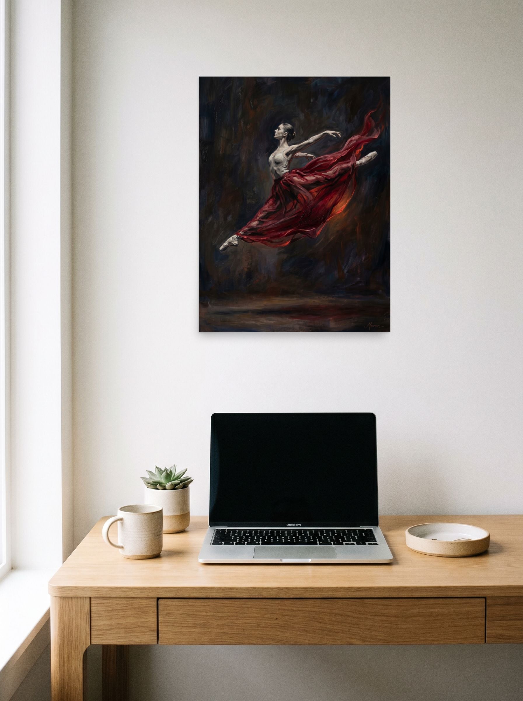 A 18x24 inch unframed paper Classical Realism,Romanticism print of 'Crimson Leap' hanging above a worktable with a laptop.