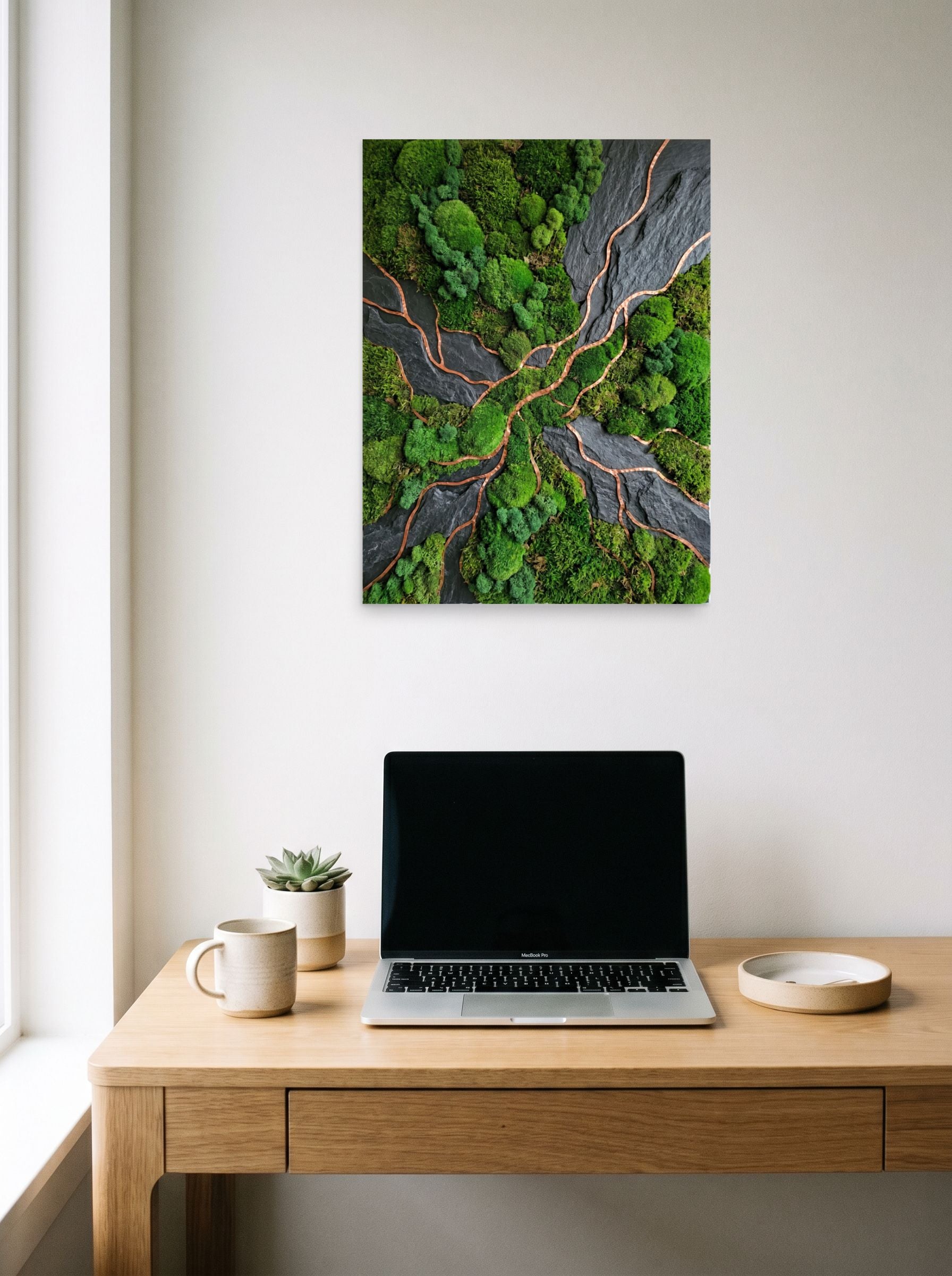 A 18x24 inch unframed paper Environmental art,Assemblage print of 'Moss and Slate' hanging above a worktable with a laptop.