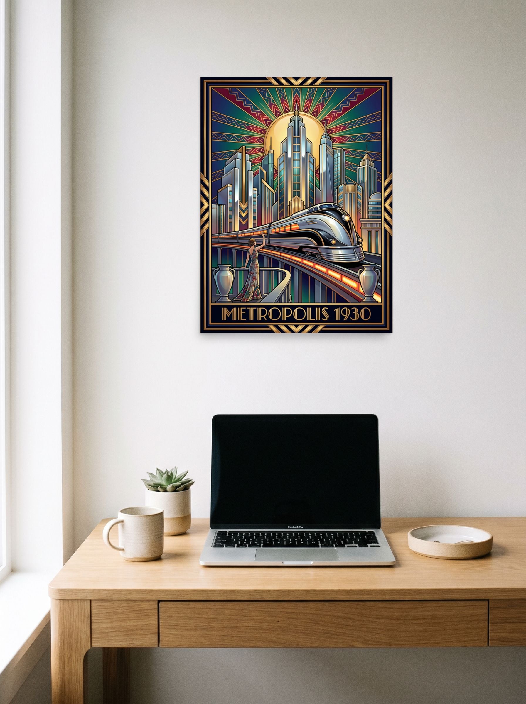 A 18x24 inch unframed paper Art Deco print of 'Monochrome Metropolis' hanging above a worktable with a laptop.