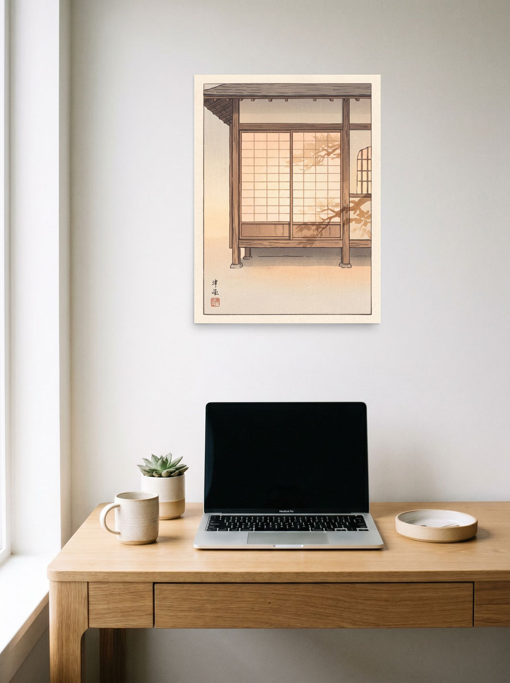A 18x24 inch unframed paper Shin hanga print of 'Shadows on Shoji' hanging above a worktable with a laptop.