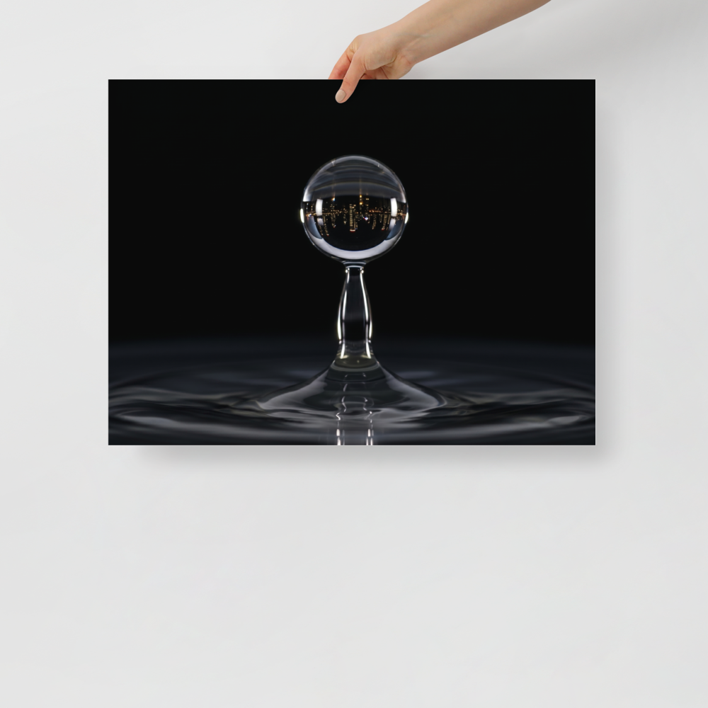 'City in a Drop' — a Surrealism print. A macro view of a water droplet splashing, containing an inverted reflection of a glowing city skyline at night.