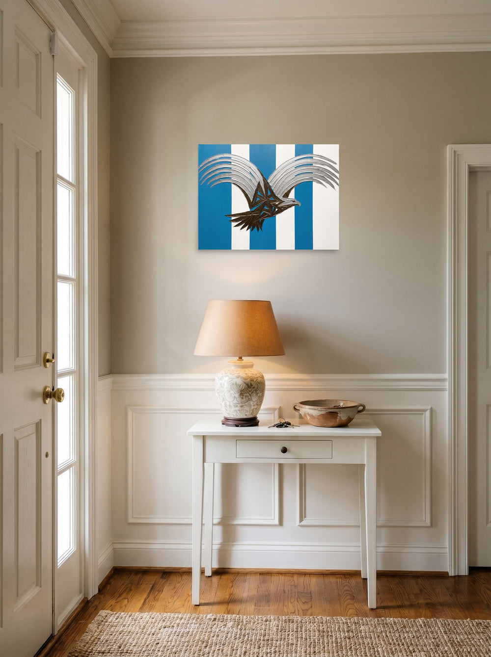 A 24x18 inch unframed paper Art Deco print of 'Deco Eagle in Flight' hanging in an entryway near a console.