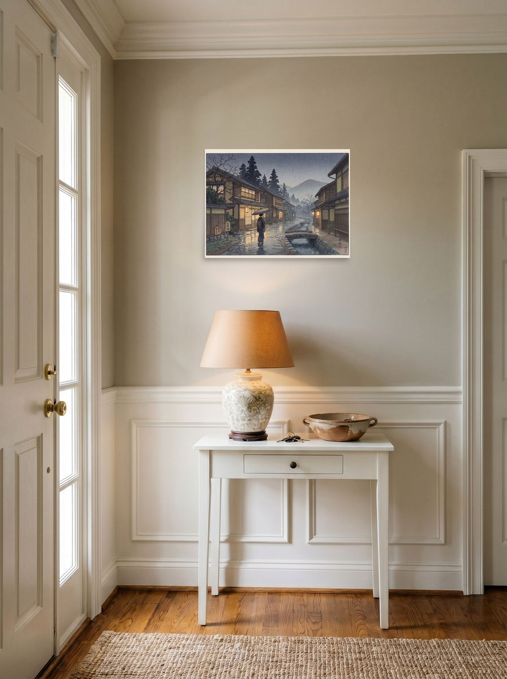 A 24x18 inch unframed paper Shin hanga print of 'Rain on Stone Street' hanging in an entryway near a console.