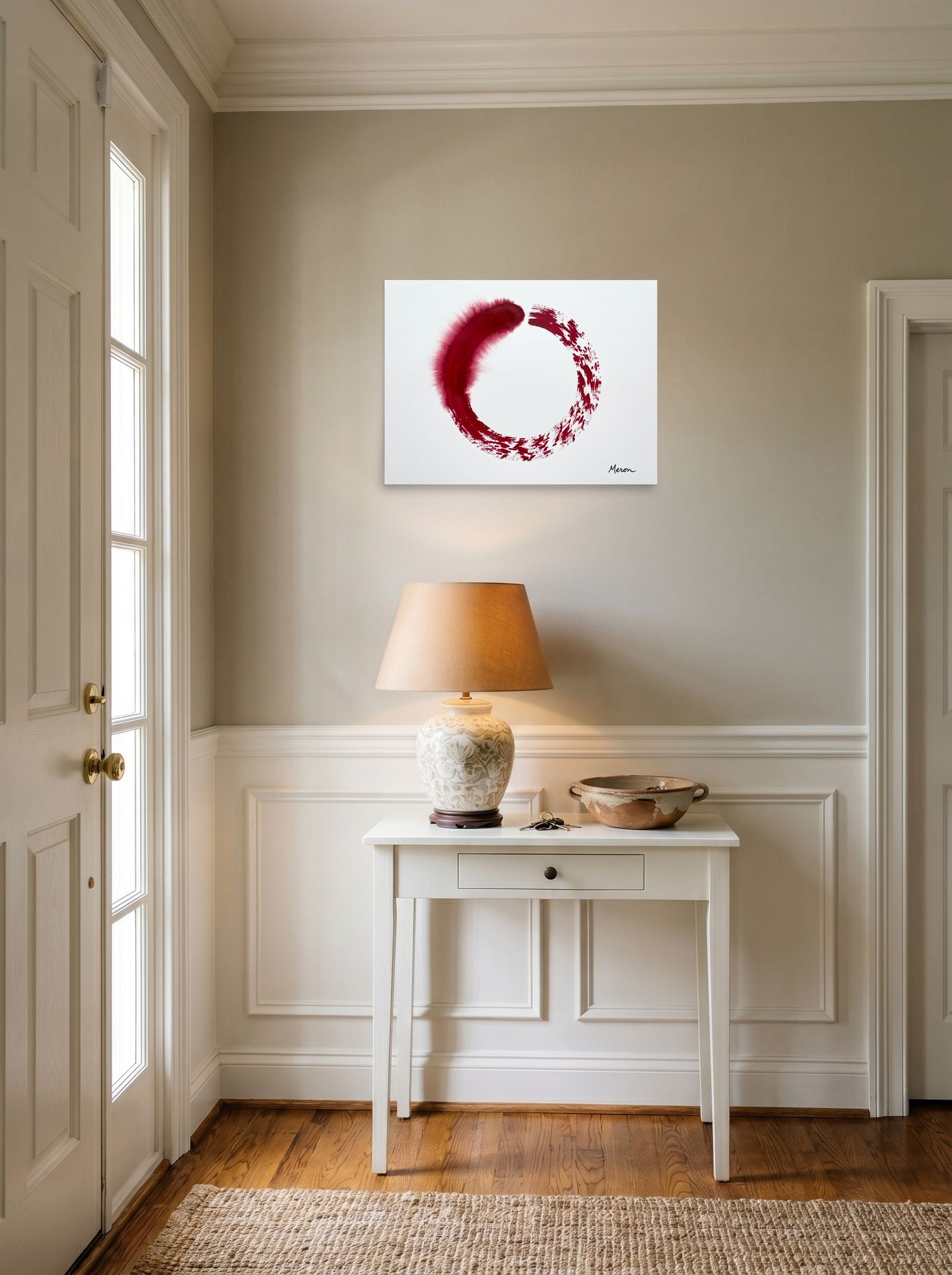 A 24x18 inch unframed paper Minimalism,Abstract expressionism print of 'Crimson Enso' hanging in an entryway near a console.