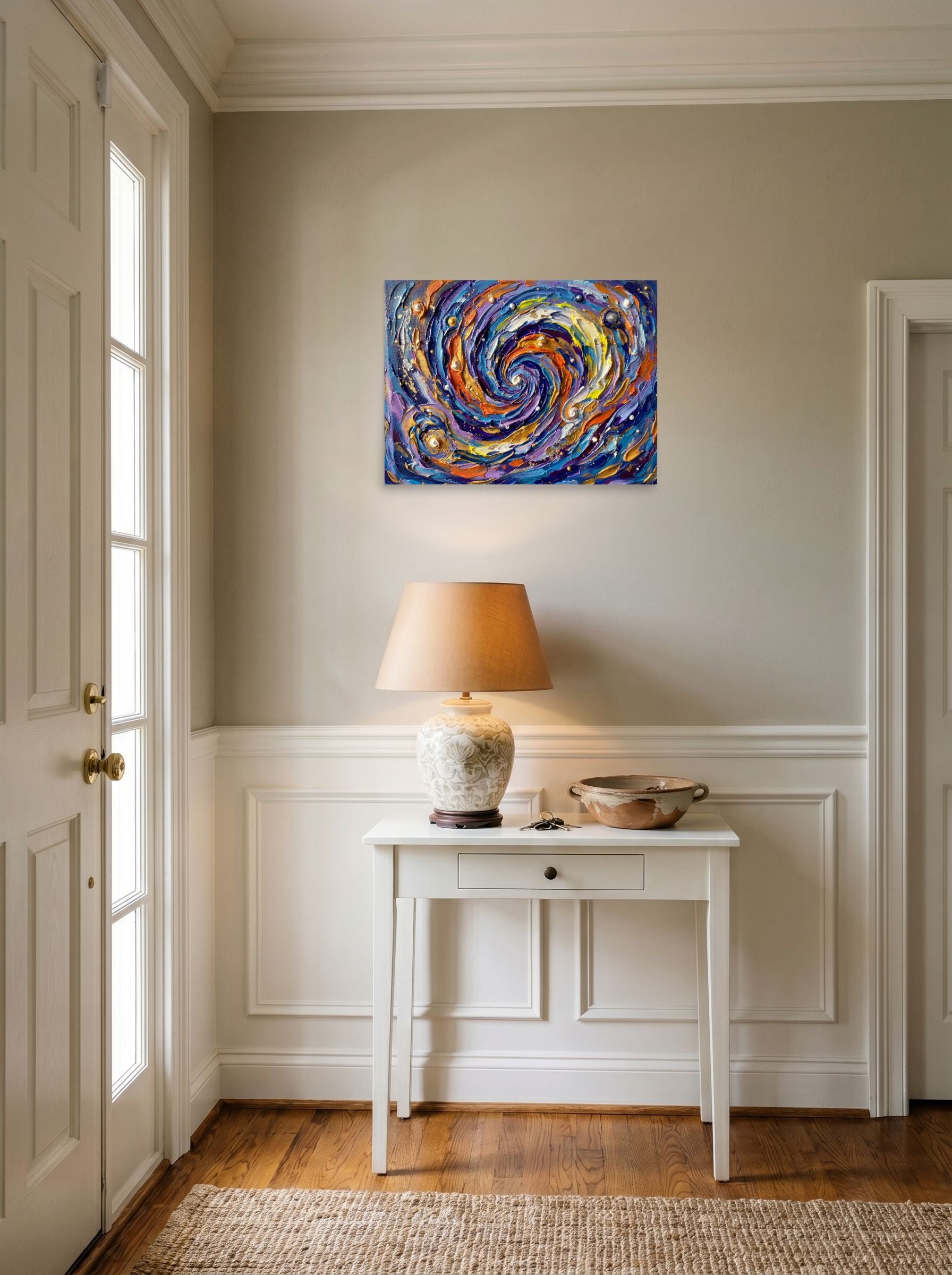 A 24x18 inch unframed paper Abstract expressionism print of 'Cosmic Swirl' hanging in an entryway near a console.