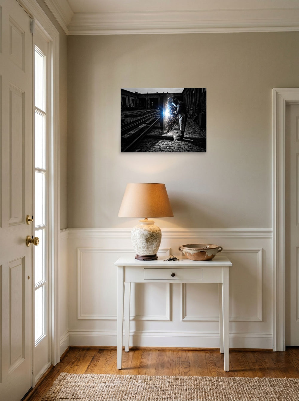 A 24x18 inch unframed paper Art photography print of 'Sparks of Labor' hanging in an entryway near a console.