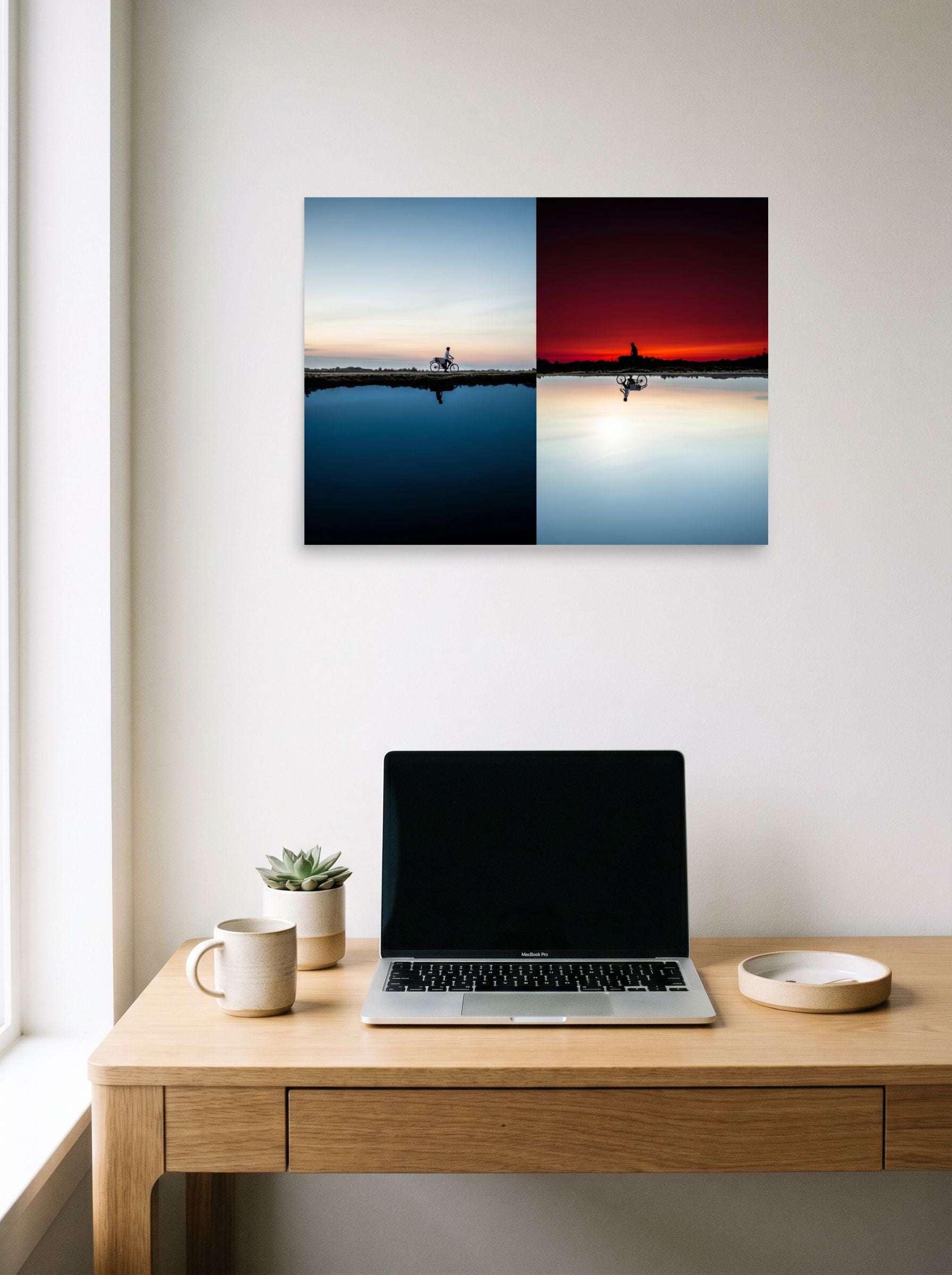 A 24x18 inch unframed paper Surrealism print of 'Two Worlds Riding' hanging above a worktable with a laptop.