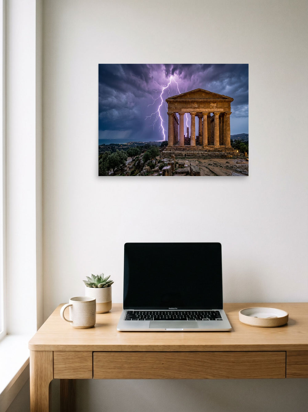 A 24x18 inch unframed paper Art photography print of 'Wrath of Olympus' hanging above a worktable with a laptop.