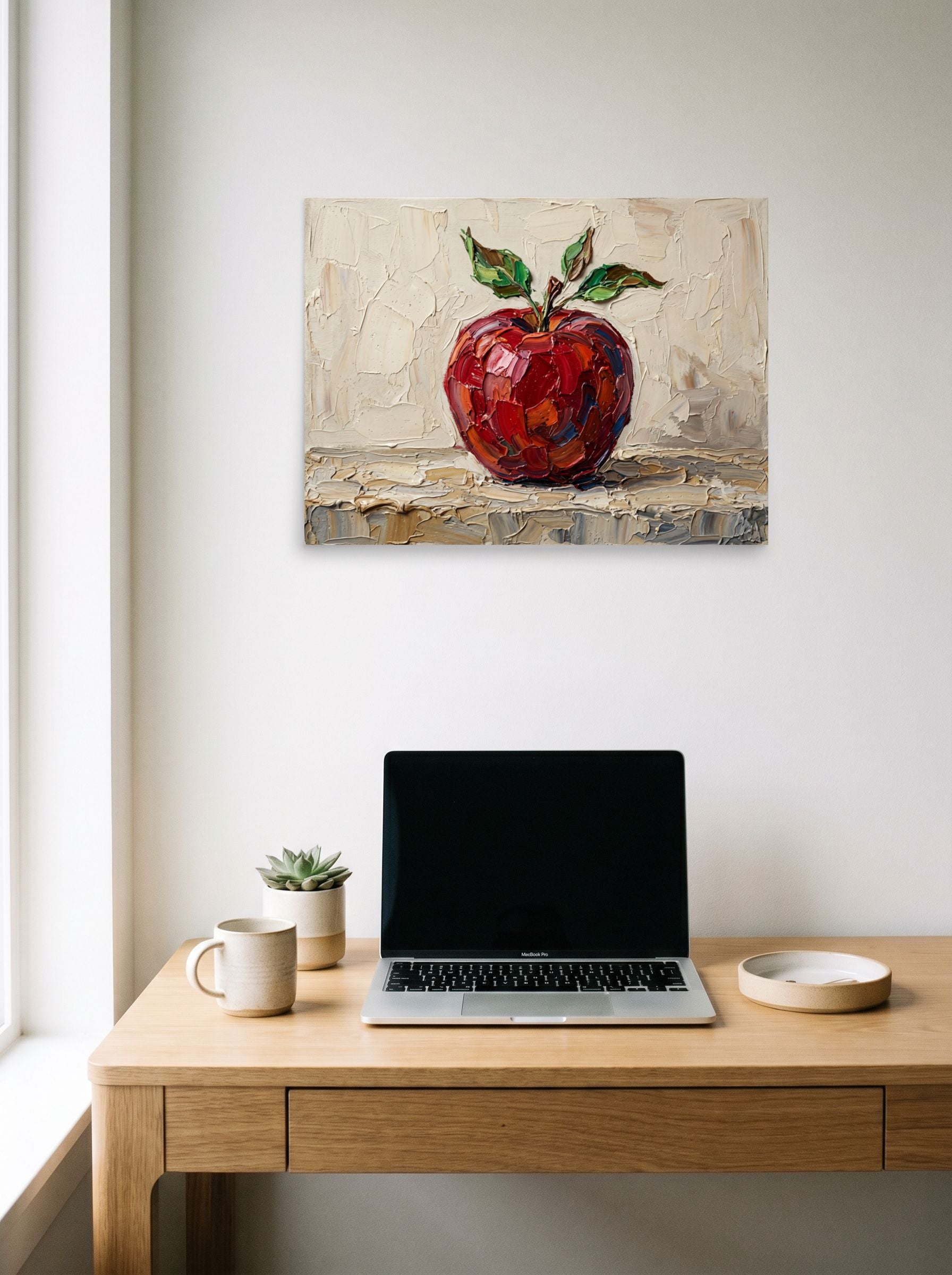A 24x18 inch unframed paper Impressionism print of 'The Impasto Apple' hanging above a worktable with a laptop.