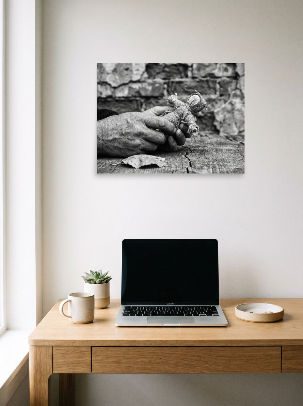 A 24x18 inch unframed paper Art photography print of 'The Keeper of Memories' hanging above a worktable with a laptop.