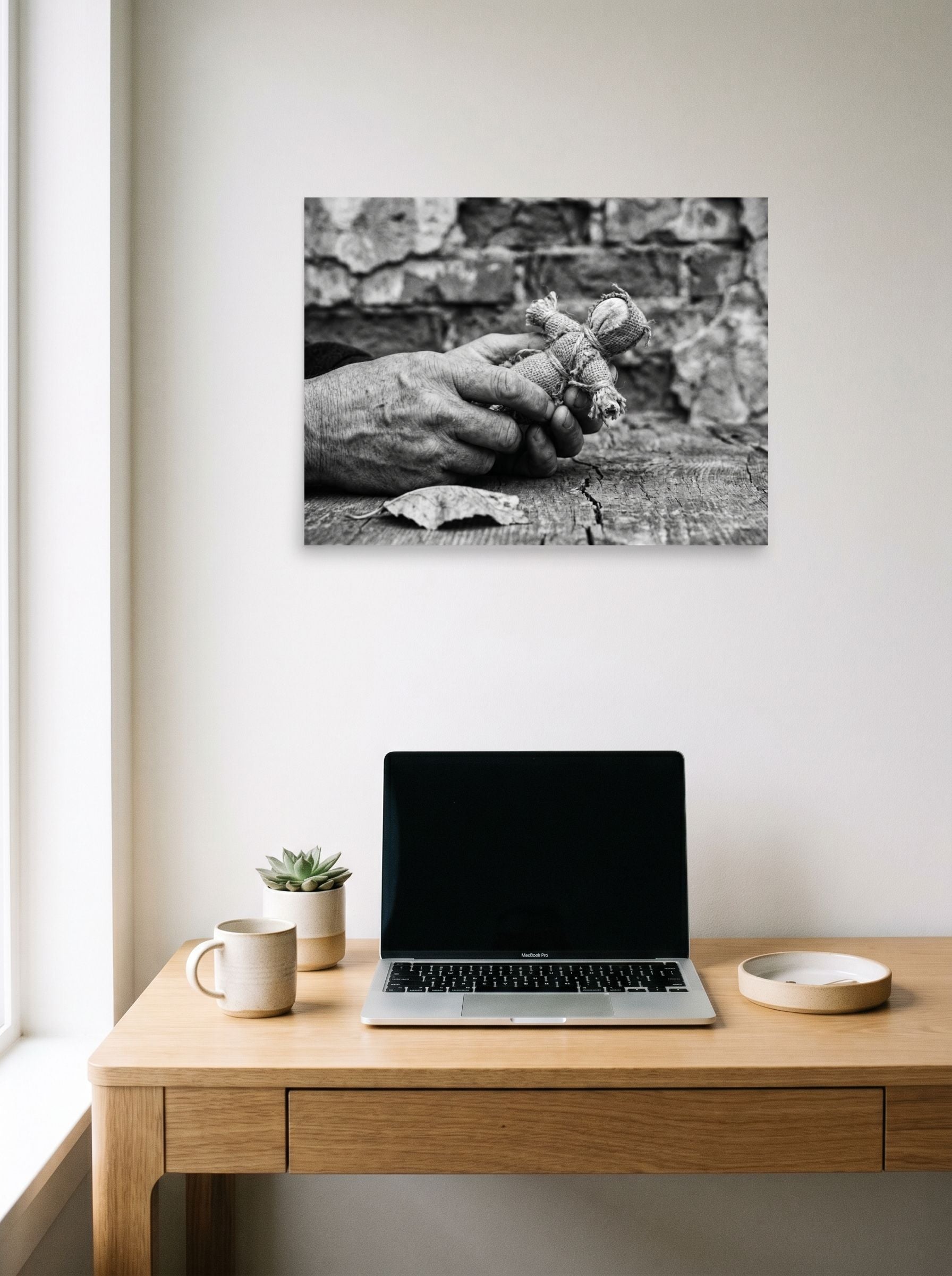 A 24x18 inch unframed paper Art photography print of 'The Keeper of Memories' hanging above a worktable with a laptop.