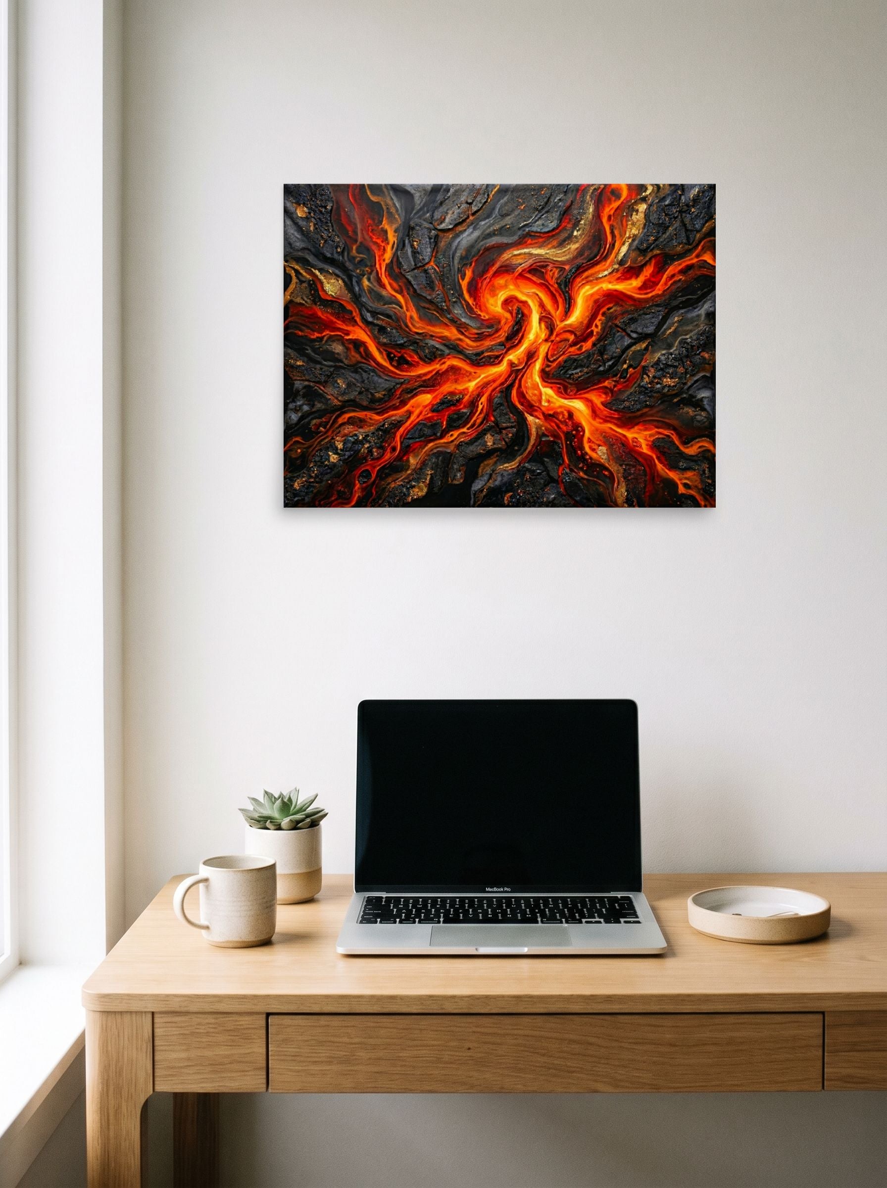 A 24x18 inch unframed paper Abstract art print of 'Molten Core' hanging above a worktable with a laptop.