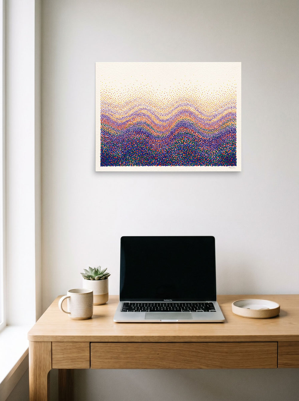 Pointillism wall art 'Spectral Ridges', unframed paper at 24x18 inch, hanging above a worktable with a laptop.