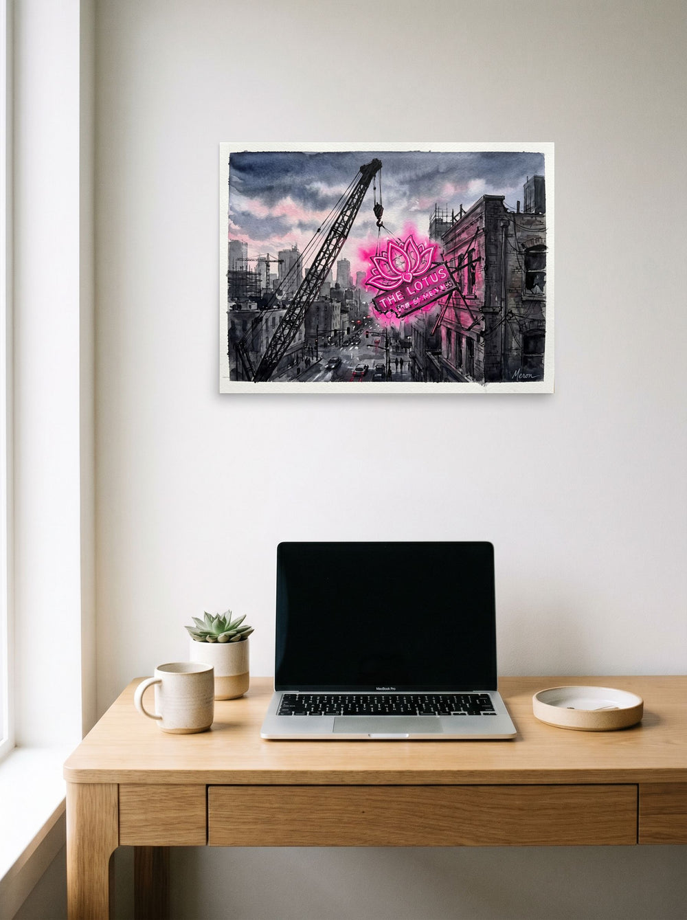 A 24x18 inch unframed paper Realism,Street art print of 'The Lotus Sign' hanging above a worktable with a laptop.