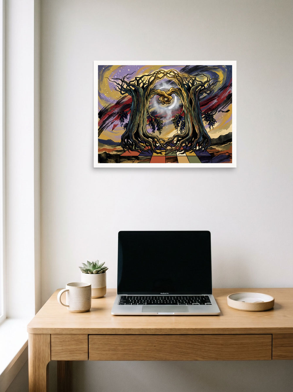 The Surrealism print 'Tree Portal', 24x18 inch unframed paper, hanging above a worktable with a laptop.