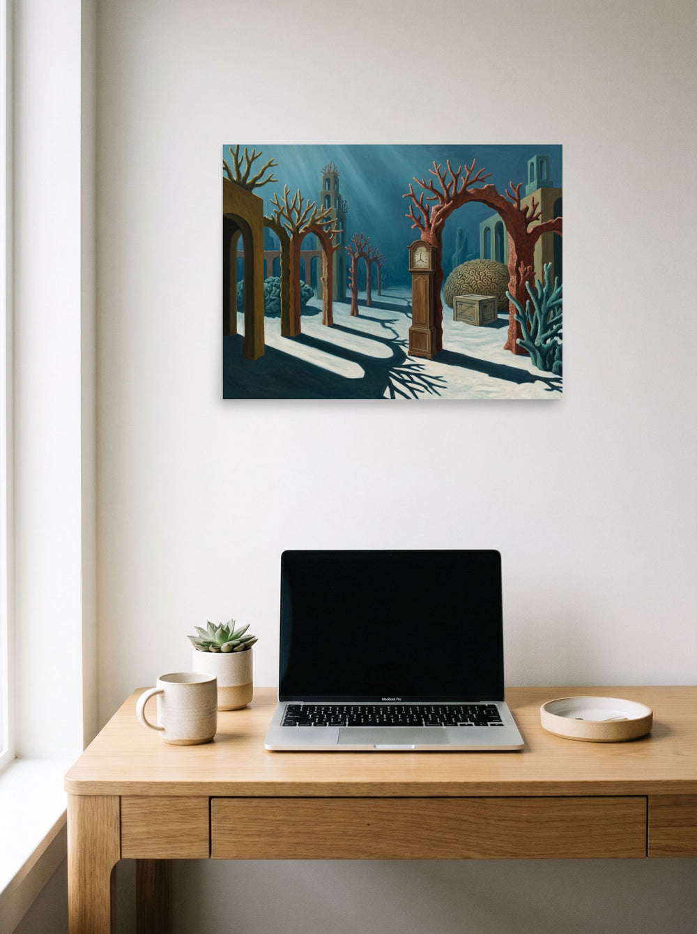 A 24x18 inch unframed paper Surrealism print of 'The Sunken Hours' hanging above a worktable with a laptop.