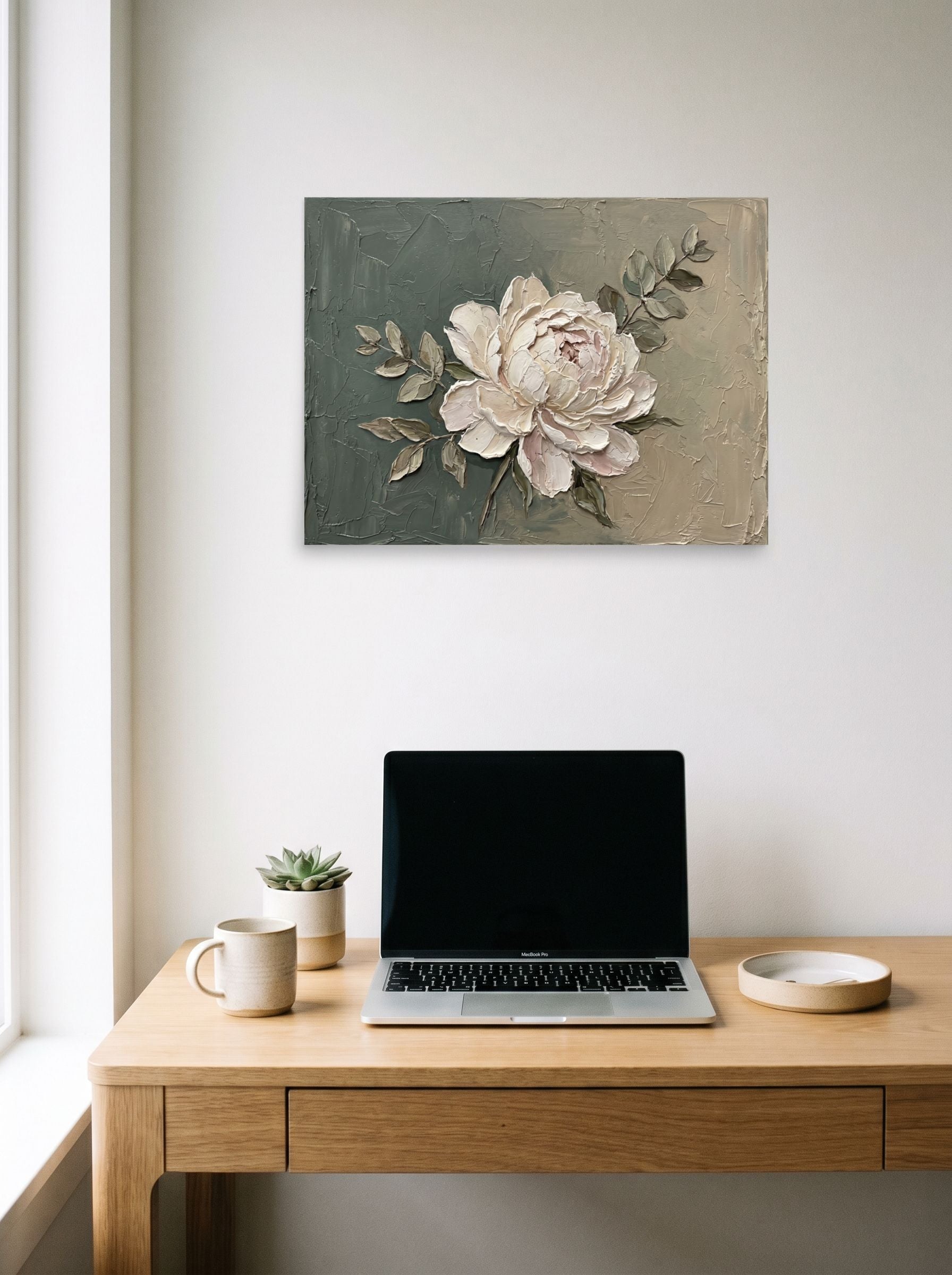A 24x18 inch unframed paper Impressionism print of 'Textured White Peony' hanging above a worktable with a laptop.
