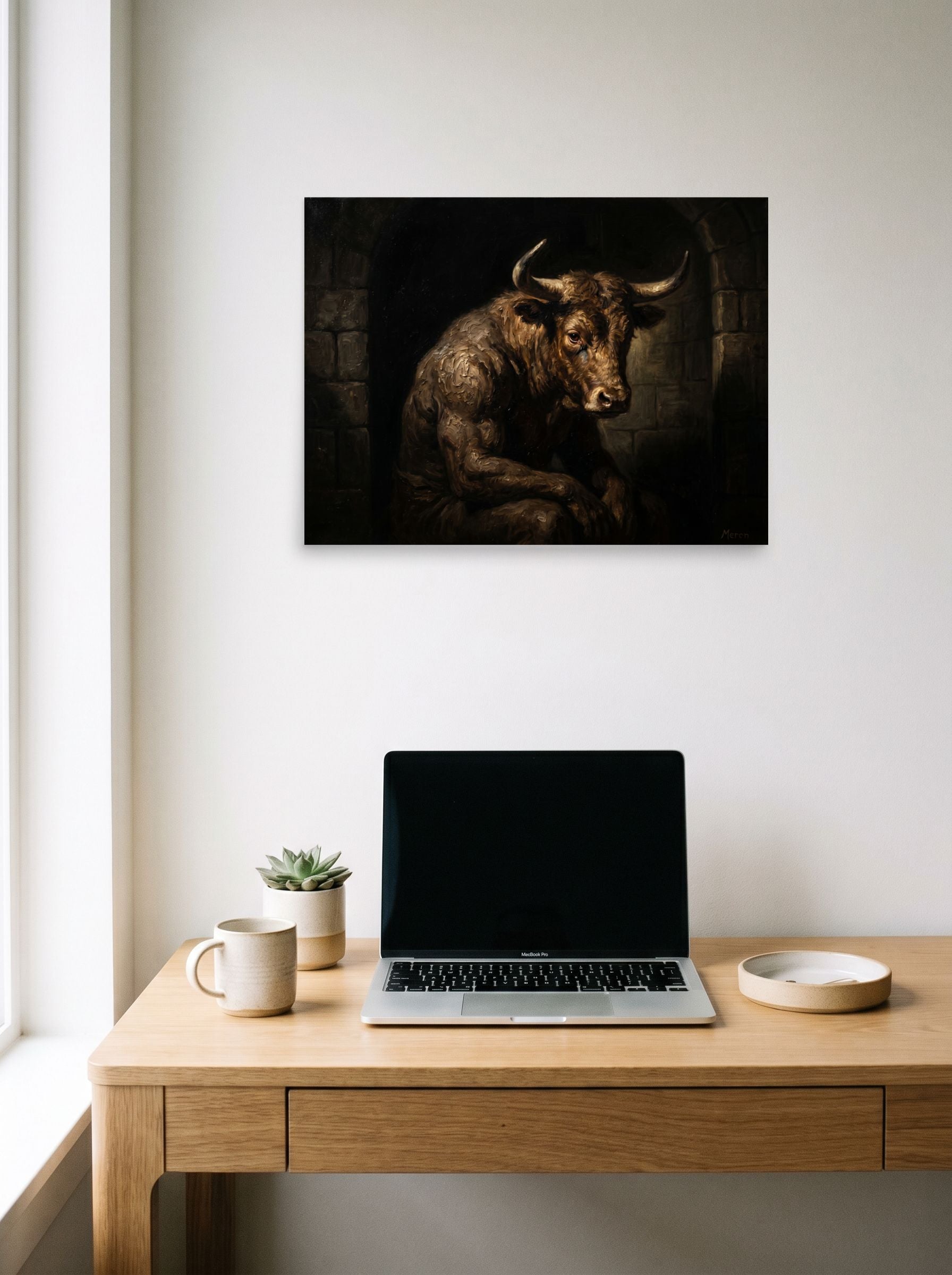 A 24x18 inch unframed paper Figurative art,Expressionism print of 'The Captive Beast' hanging above a worktable with a laptop.