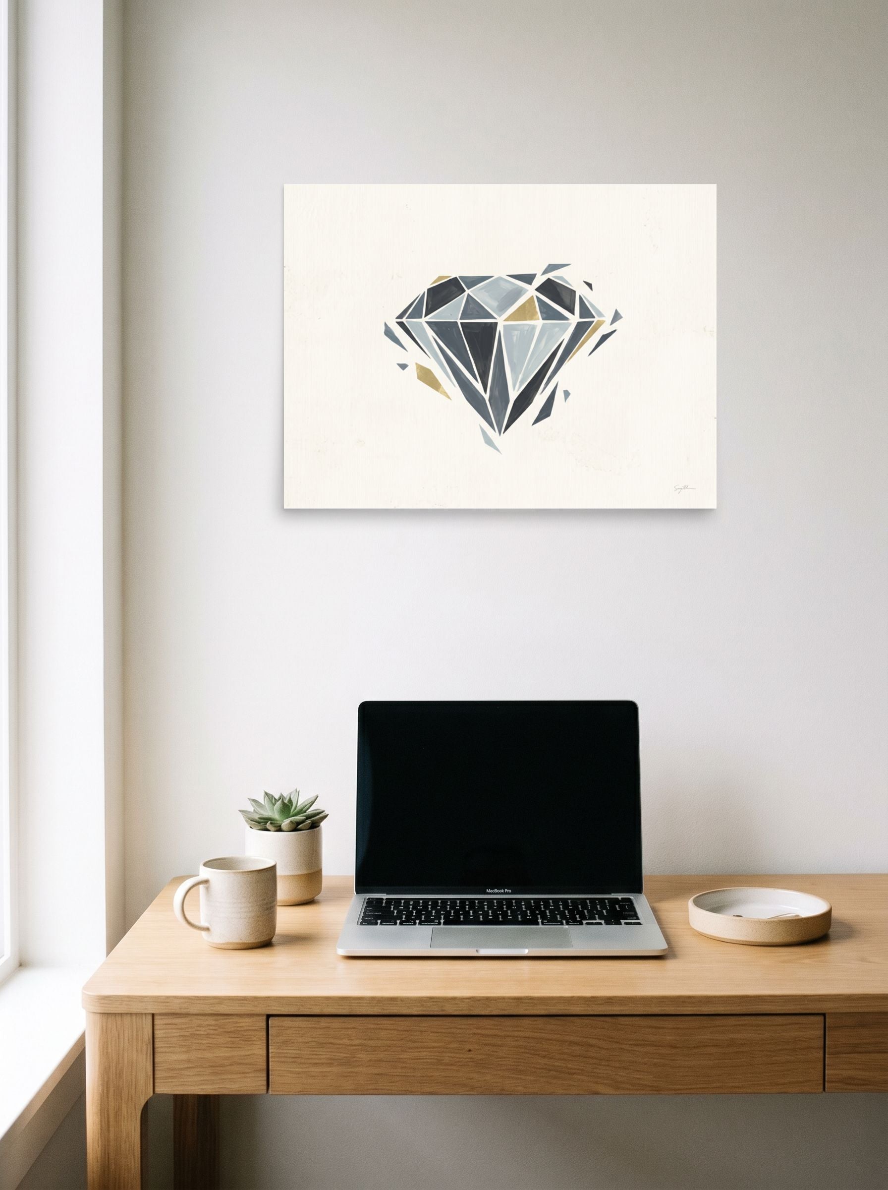 A 24x18 inch unframed paper Geometric abstract art print of 'Shattered Elegance' hanging above a worktable with a laptop.