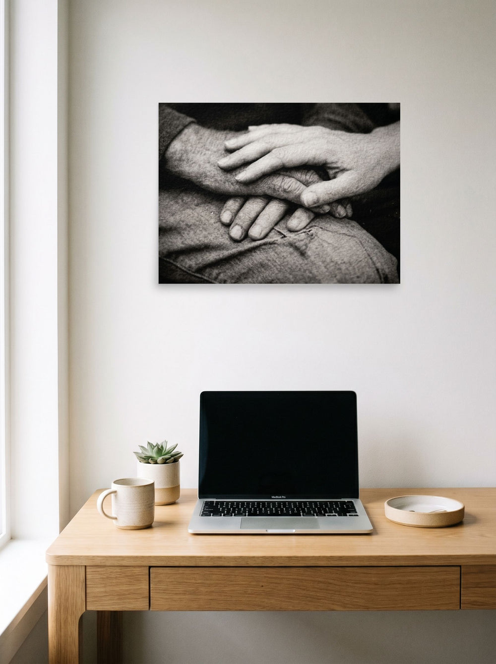 A 24x18 inch unframed paper Art photography print of 'A Lasting Touch' hanging above a worktable with a laptop.