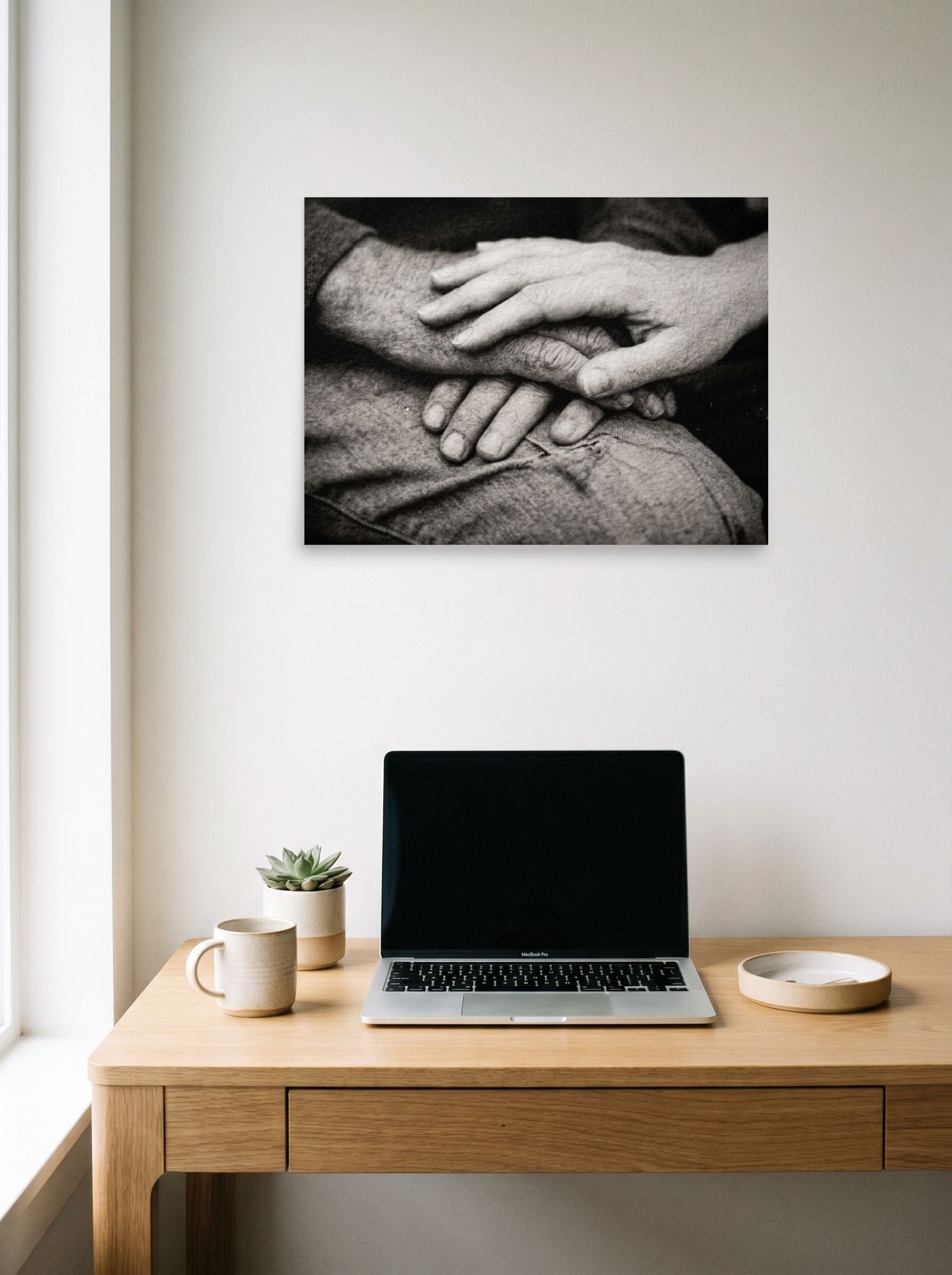 A 24x18 inch unframed paper Art photography print of 'A Lasting Touch' hanging above a worktable with a laptop.